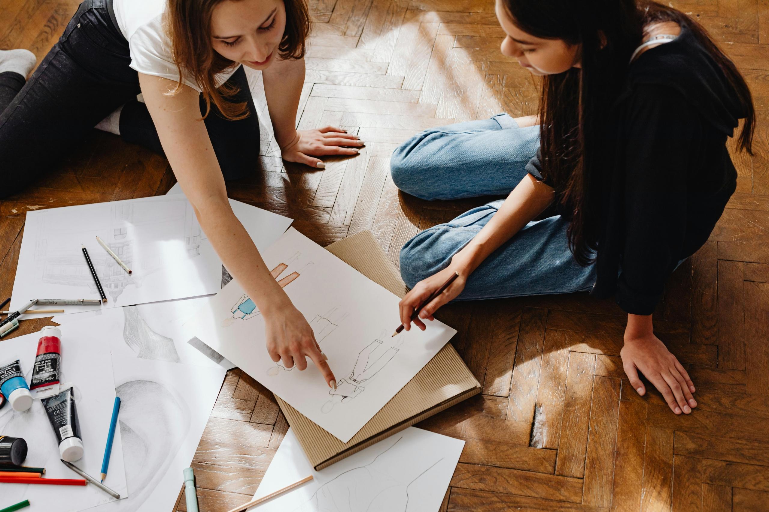 fashion design teacher showing student how to sketch