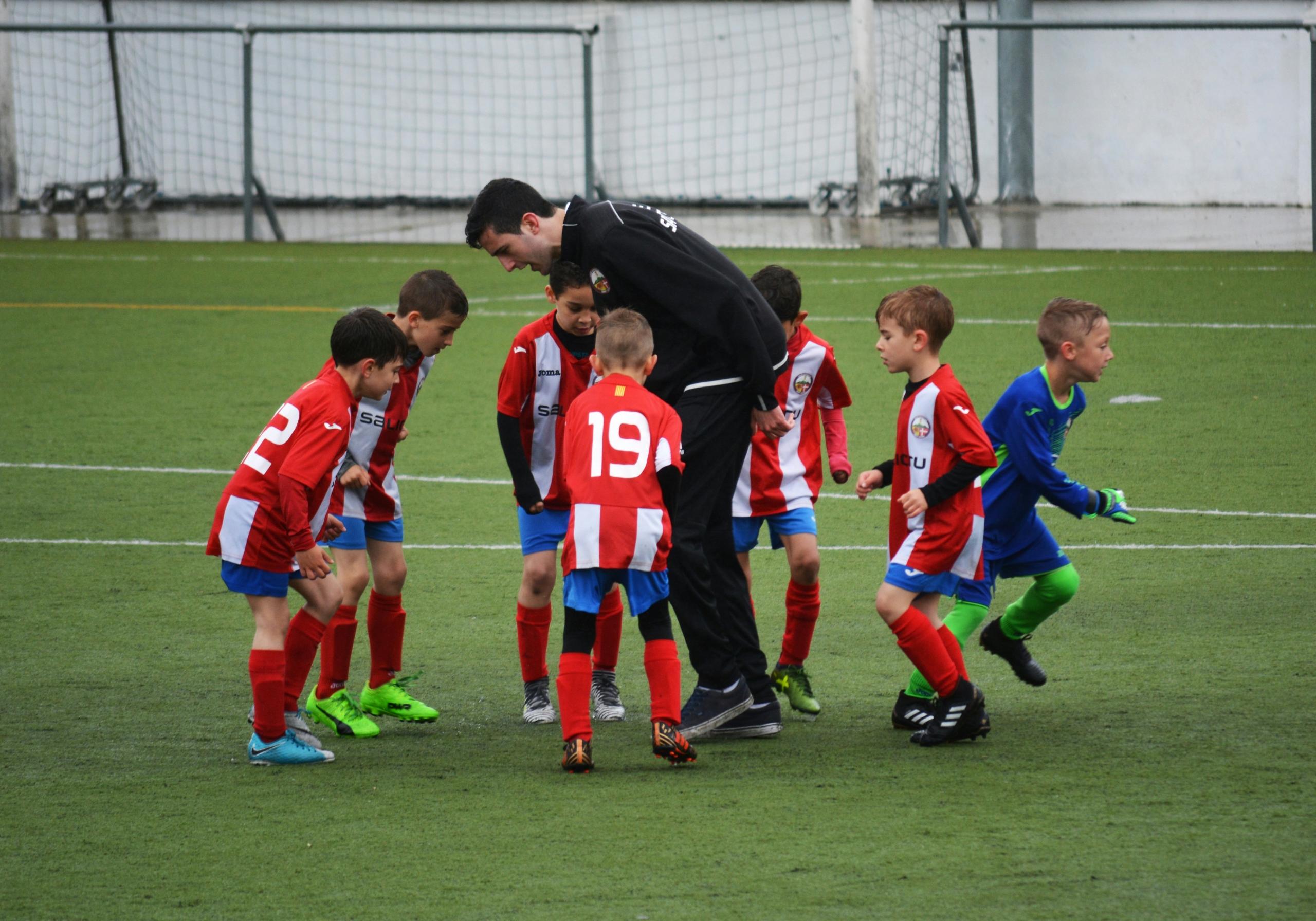 group of young boys in soccer training session with coach