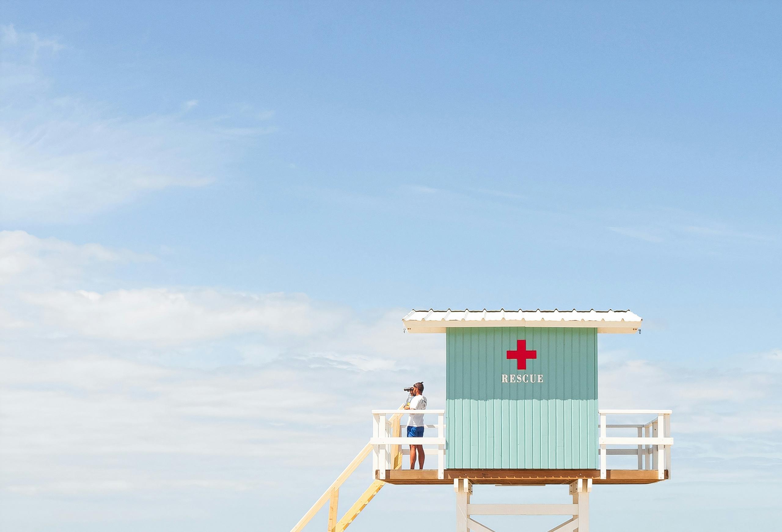 lifeguard using binoculars to survey the beach