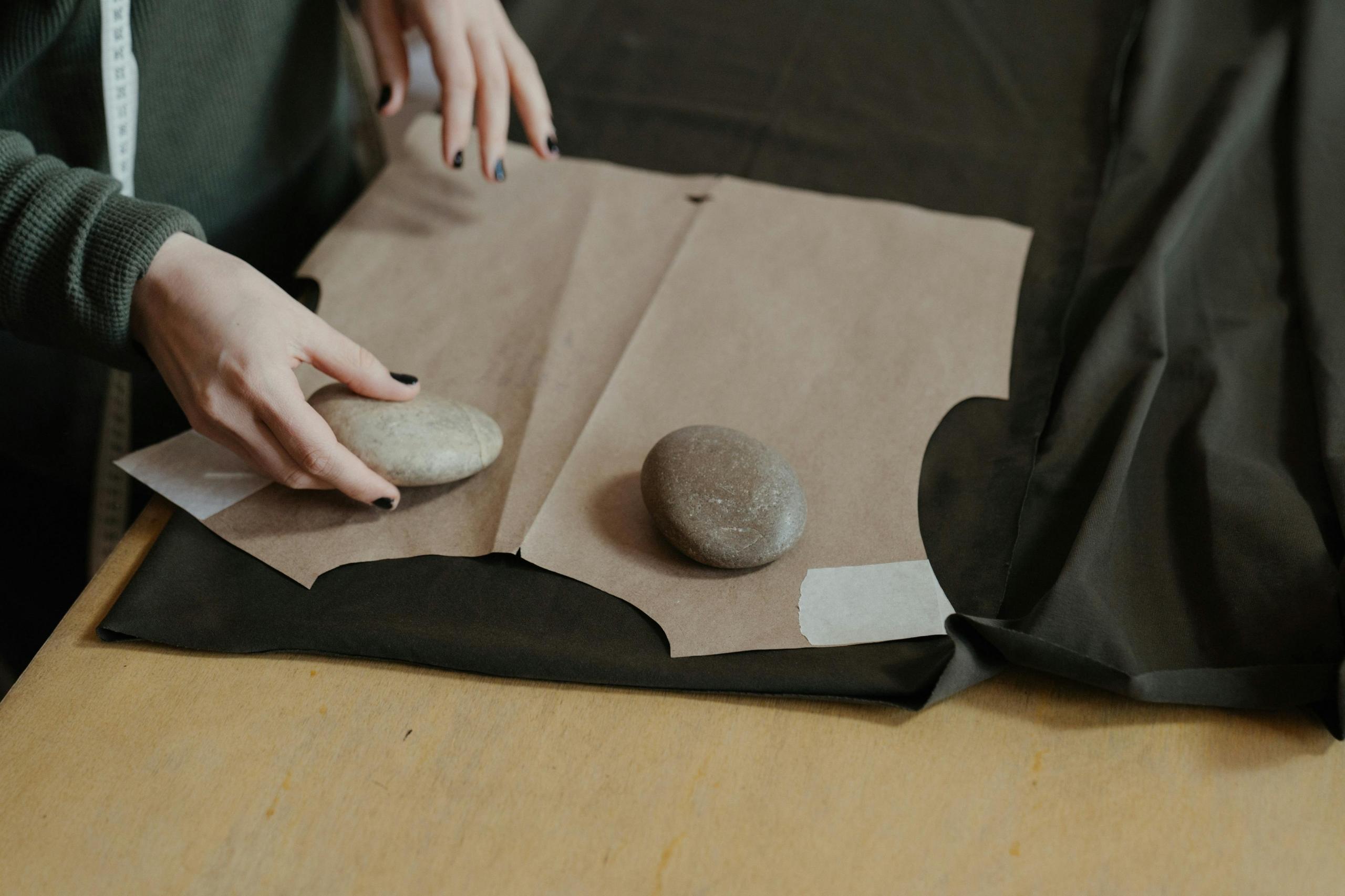 patternmaker using sweing weights to weigh down material and trace pattern
