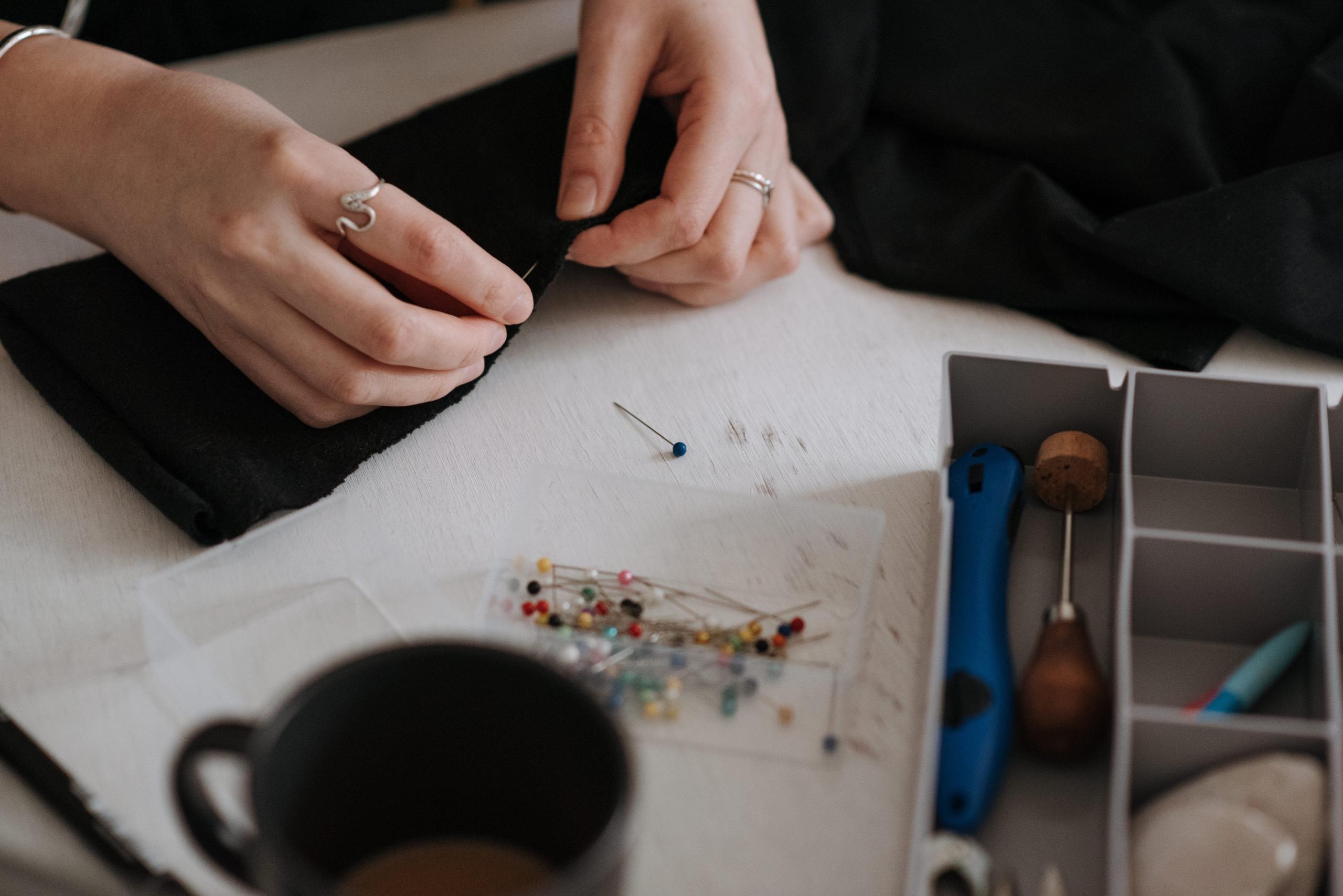 woman pinning fabric with ball-point pins