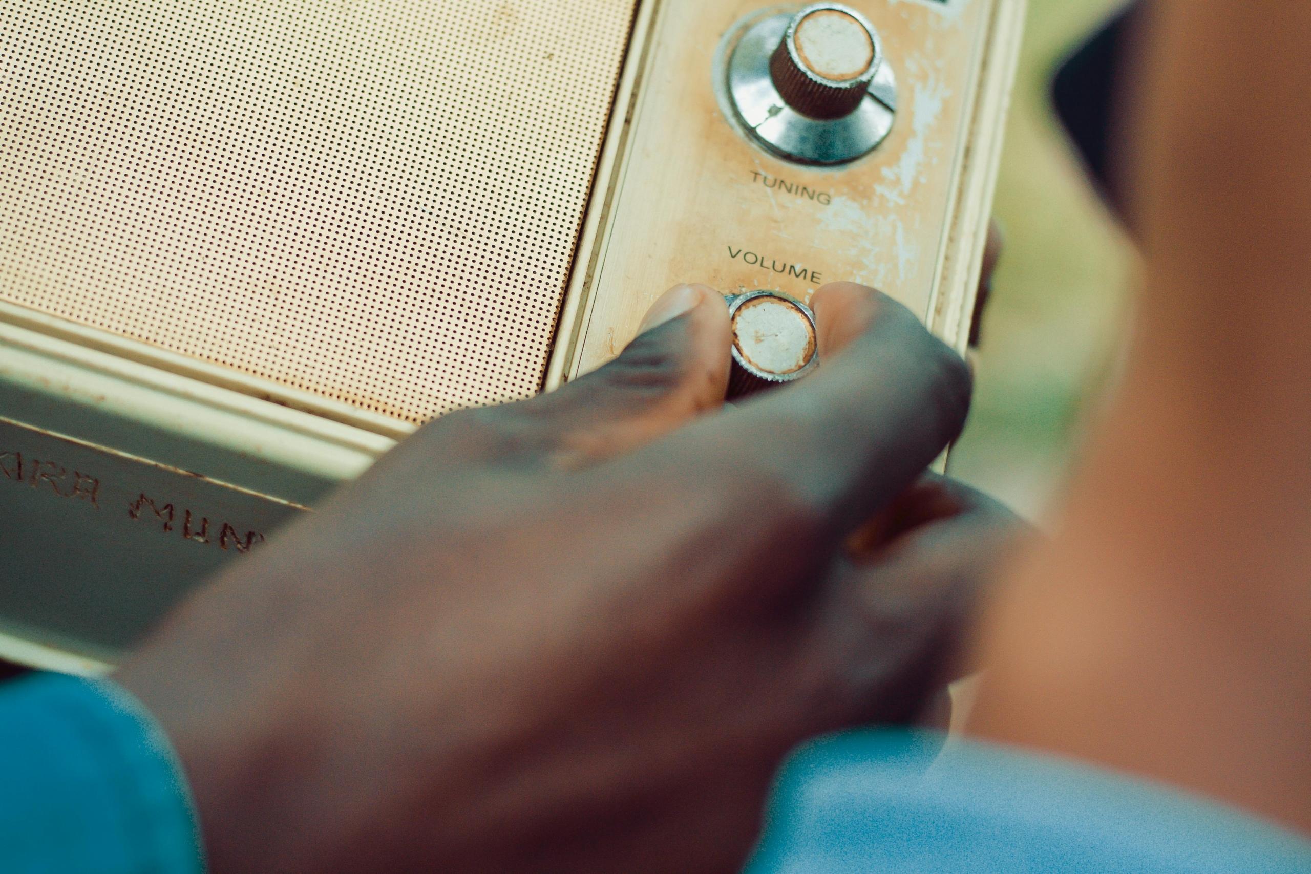 man adjusting volume settings on antique radio