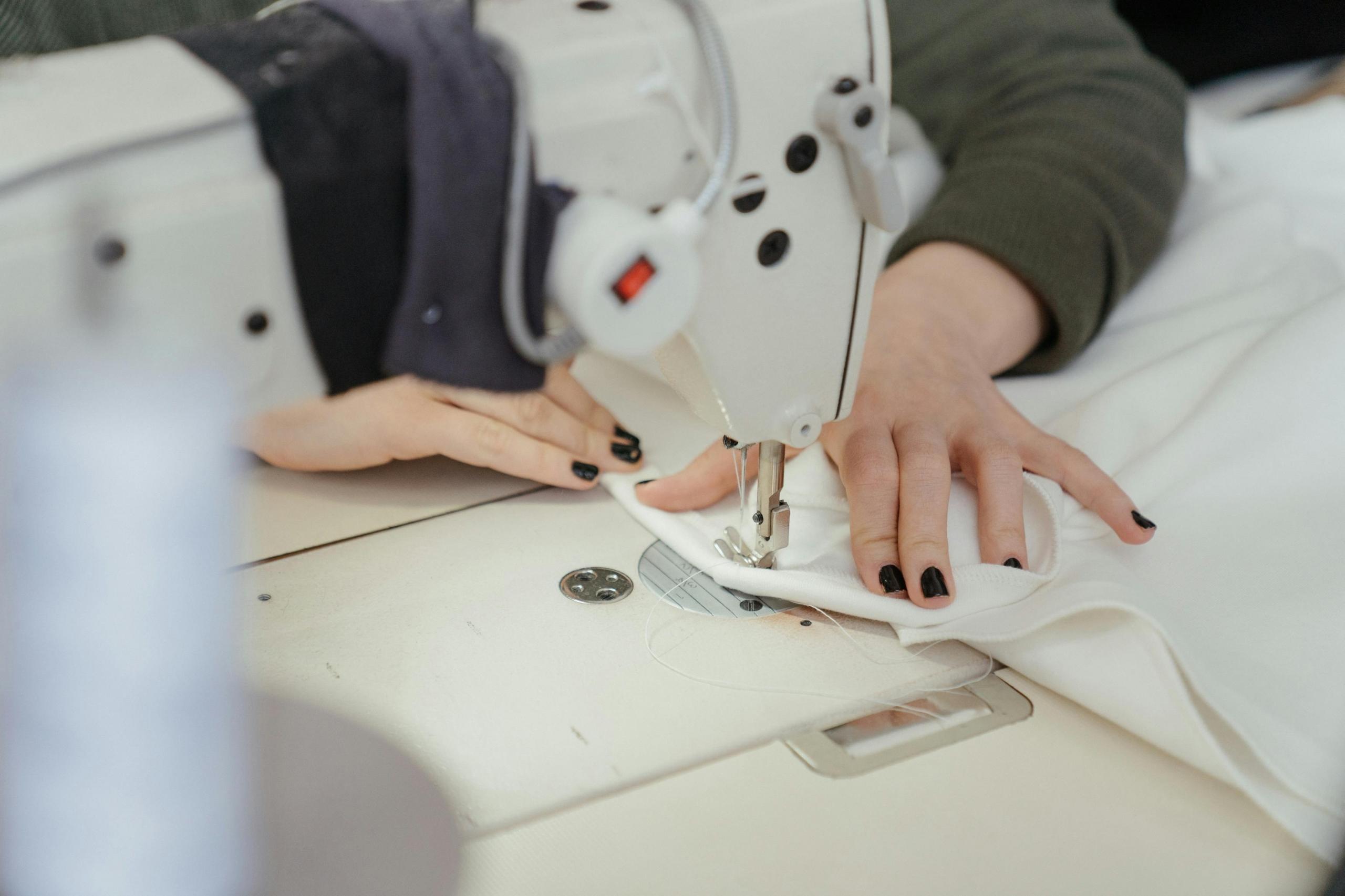 seamstress stitching garment with sewing machine