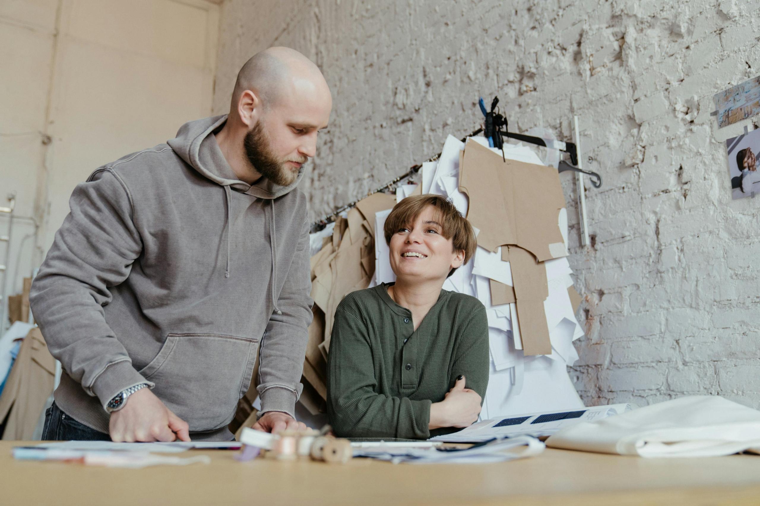 sewing student and sewing teacher looking at pattern and sketch on table in studio