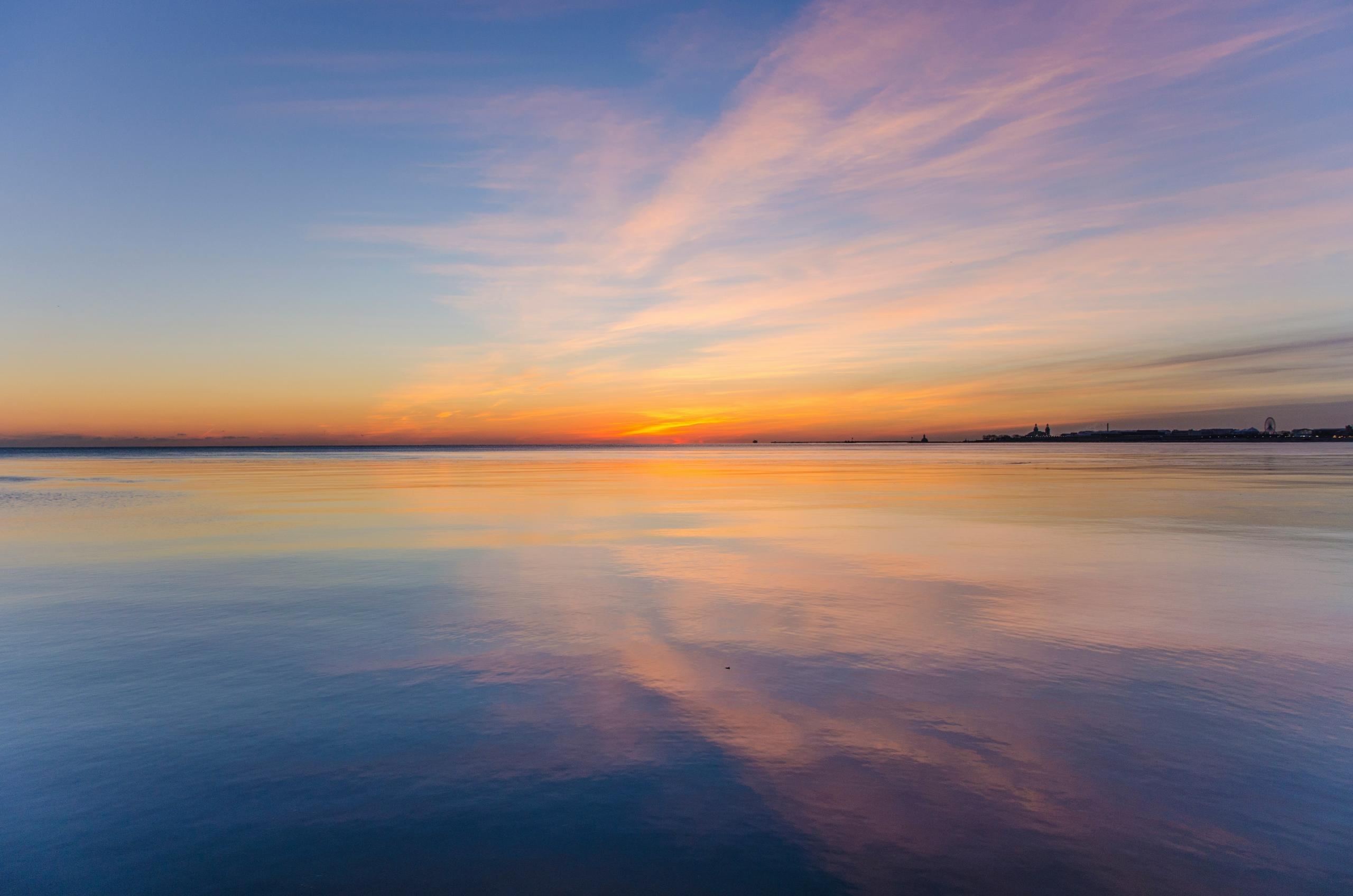 light from sunset reflected on wet sand of the beach