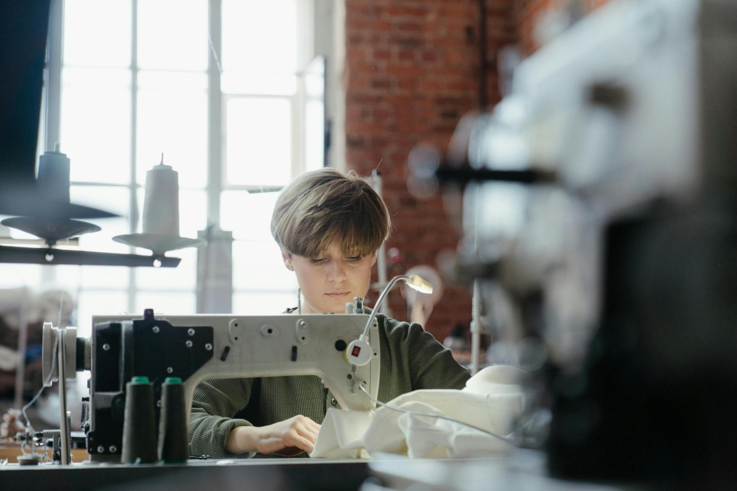 seamstress sewing garments in brick studio
