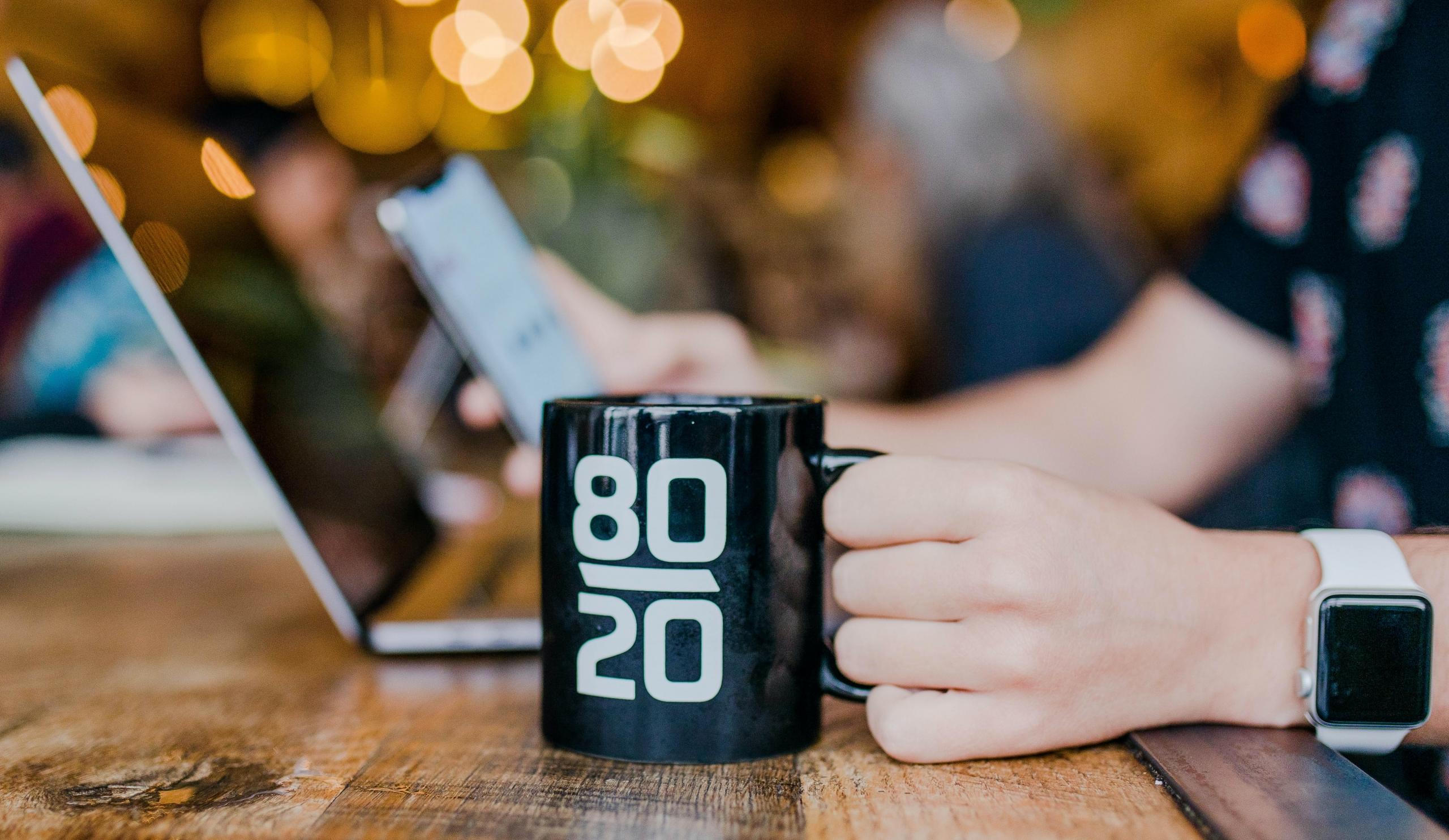 person using smartphone and laptop in co-working space