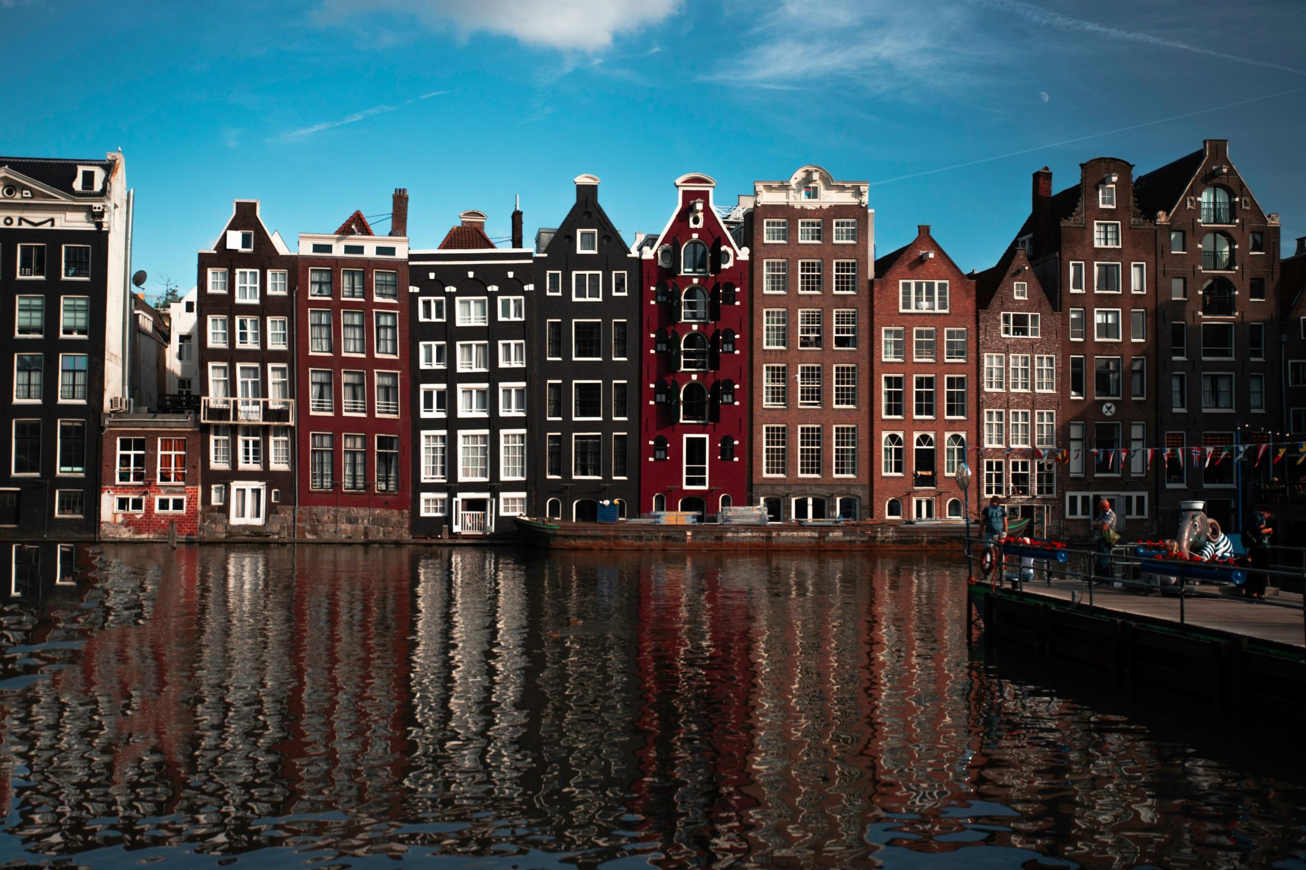 brown gingerbread buildings of amsterdam seen from across a canal