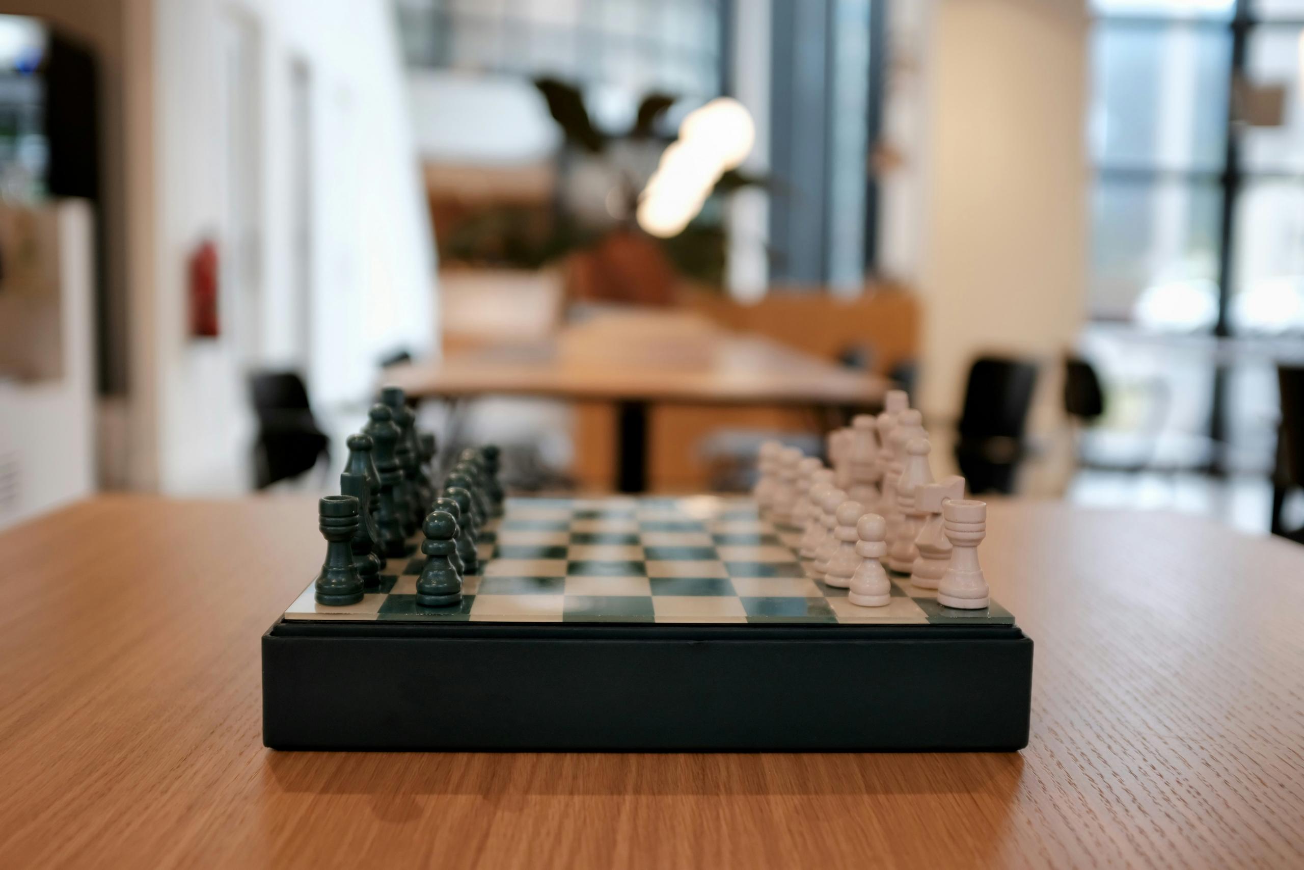 chess pieces arranged on chess board in an empty room