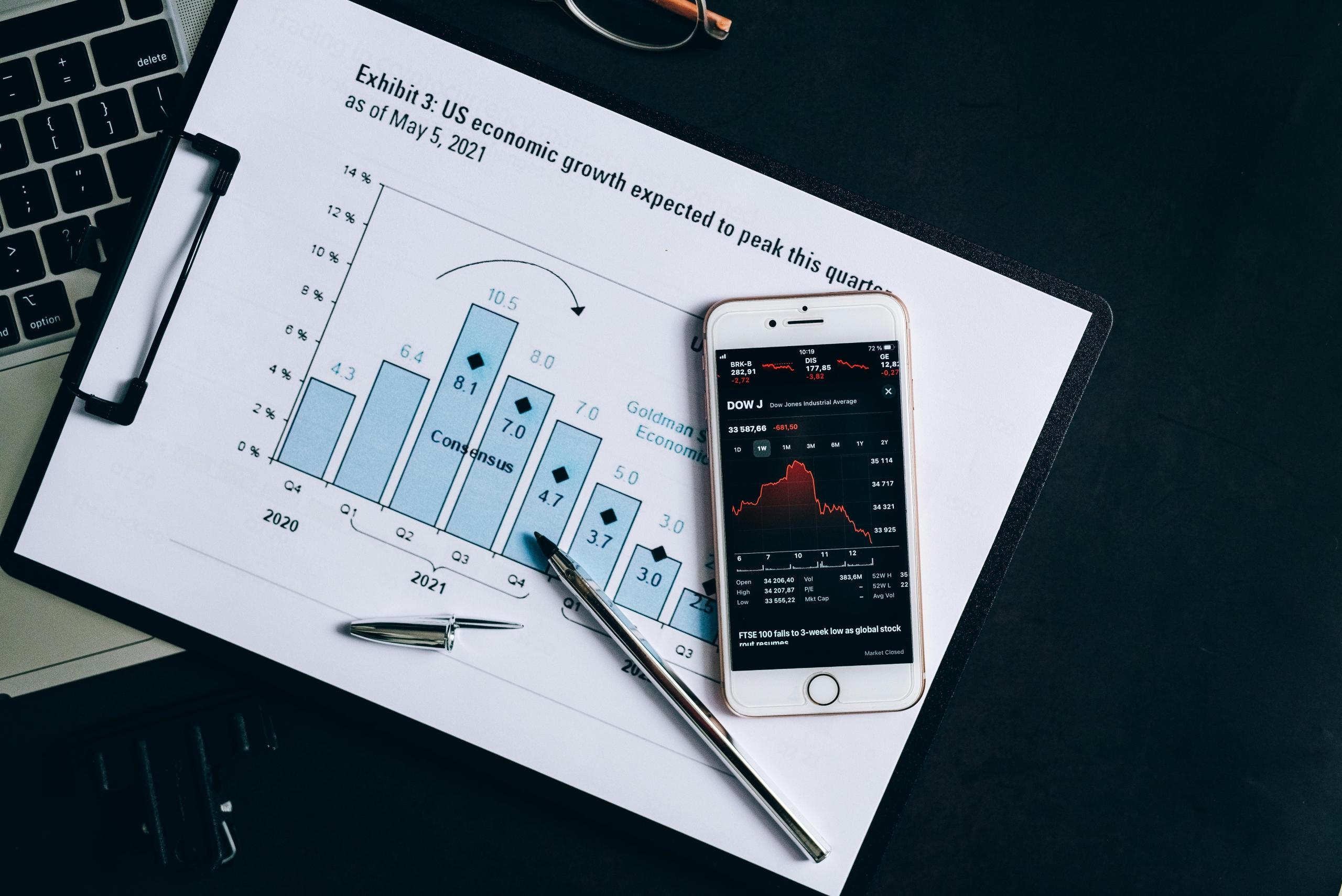 phone showing graphs placed on top of a printout of bar graphs with data points