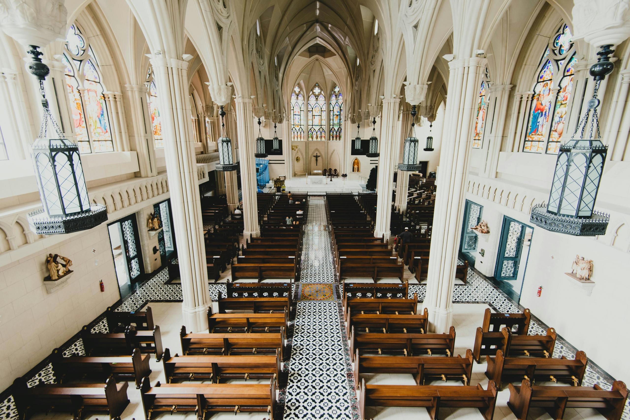 church interior with white pillars and wooden pews