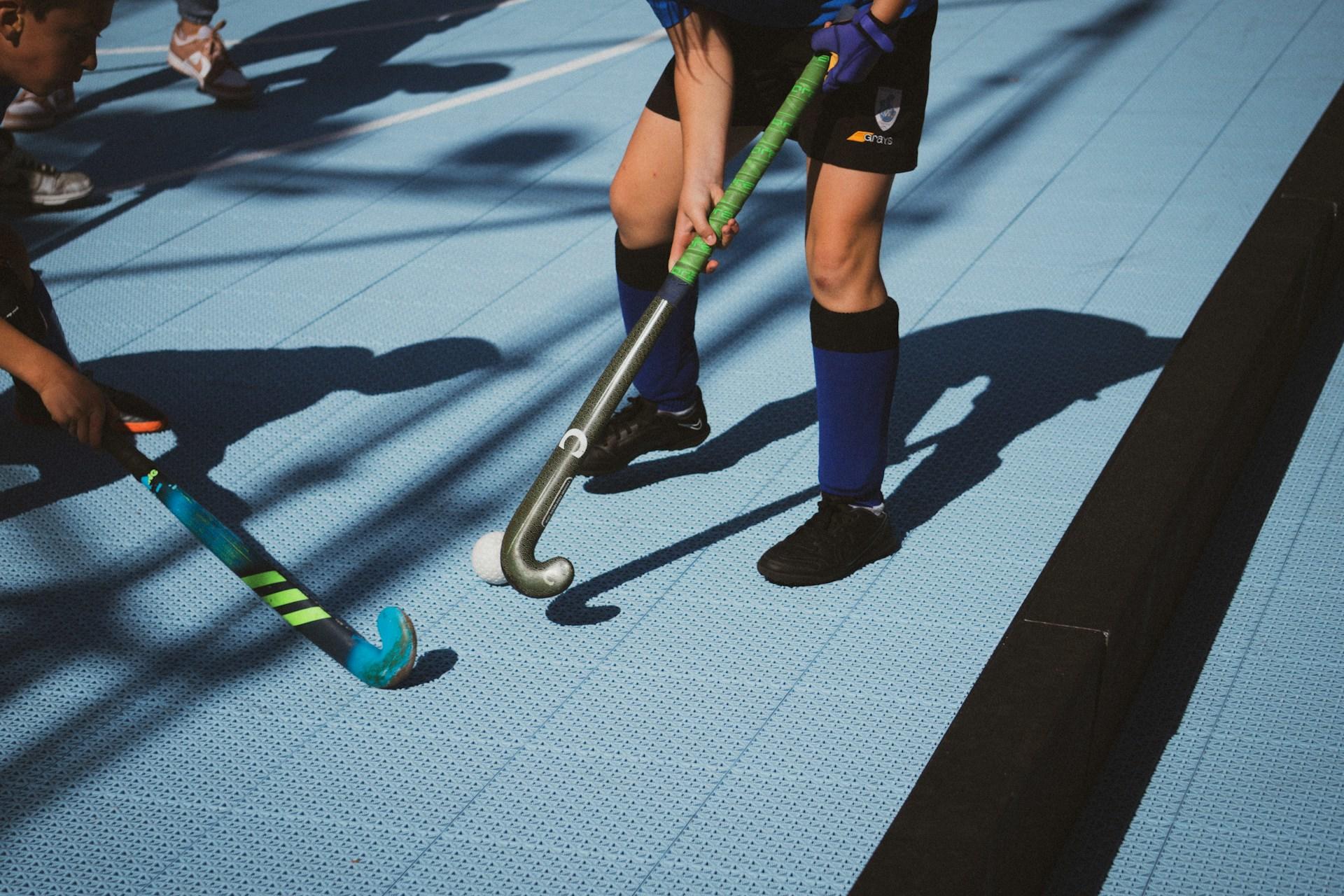 Two people playing with hockey sticks