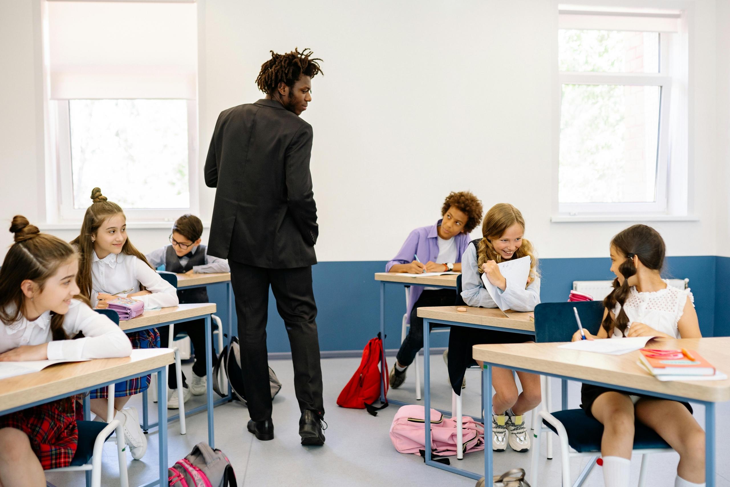 Teacher walking amongst students in Classroom