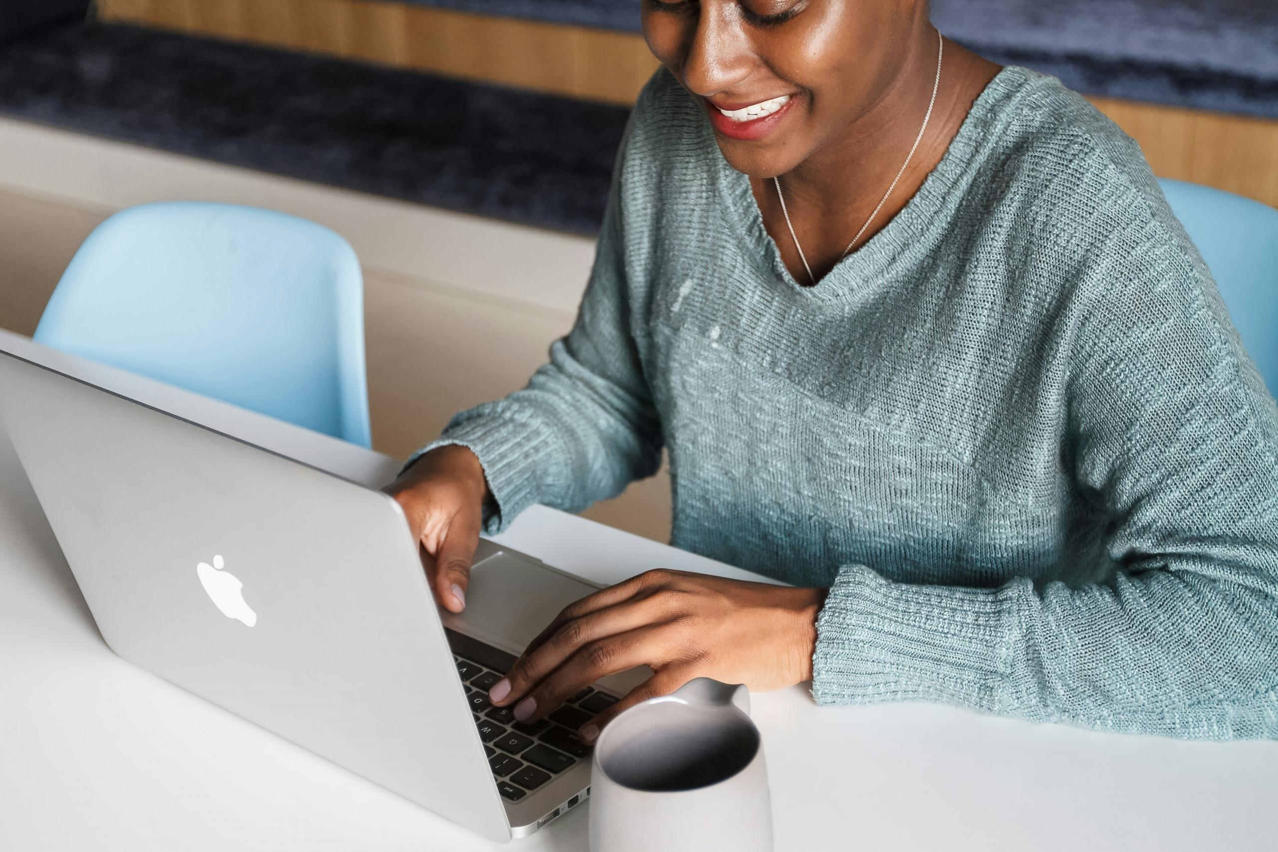 businesswoman sitting at desk working on laptop