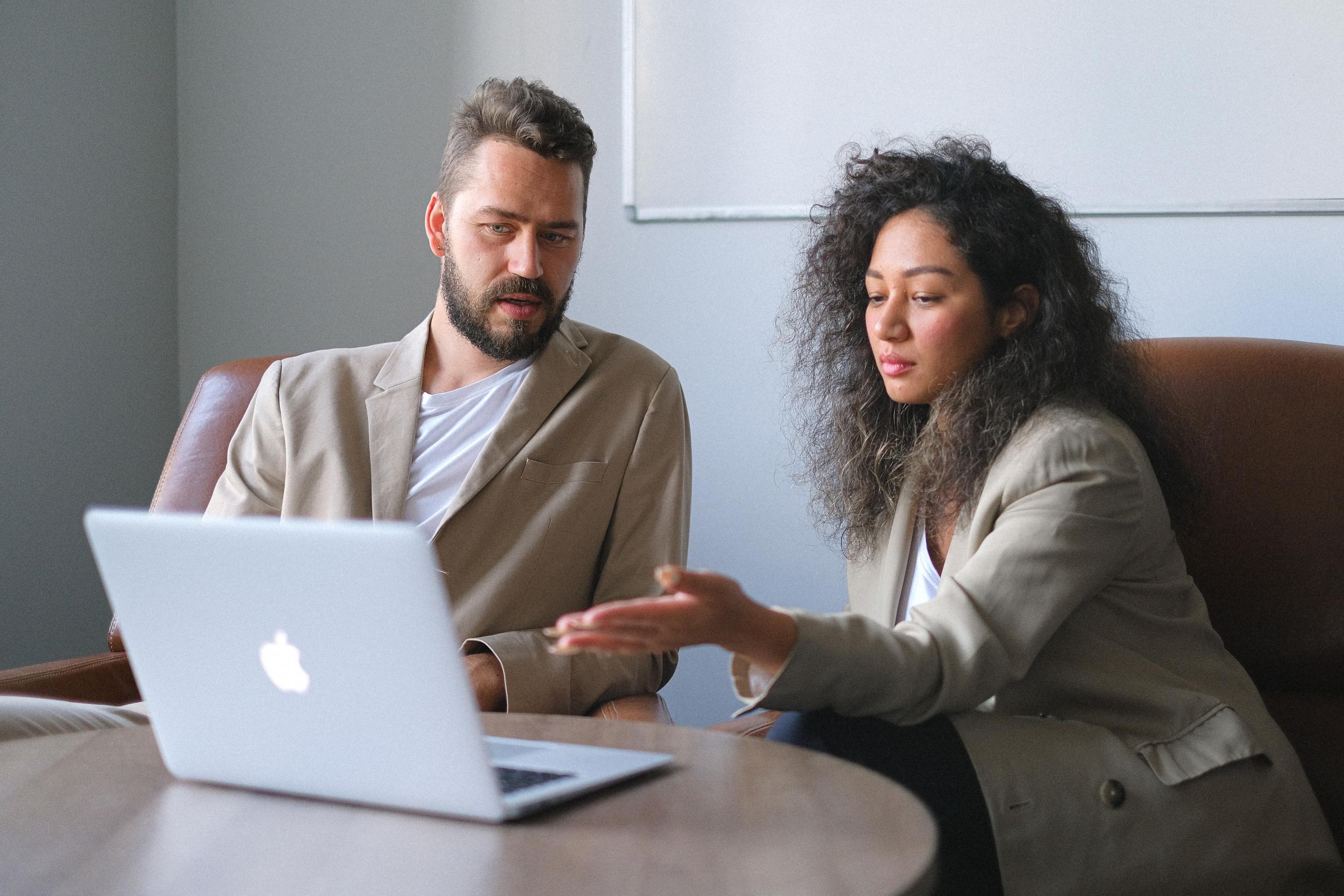two people looking at laptop trying to figure out a problem on the screen