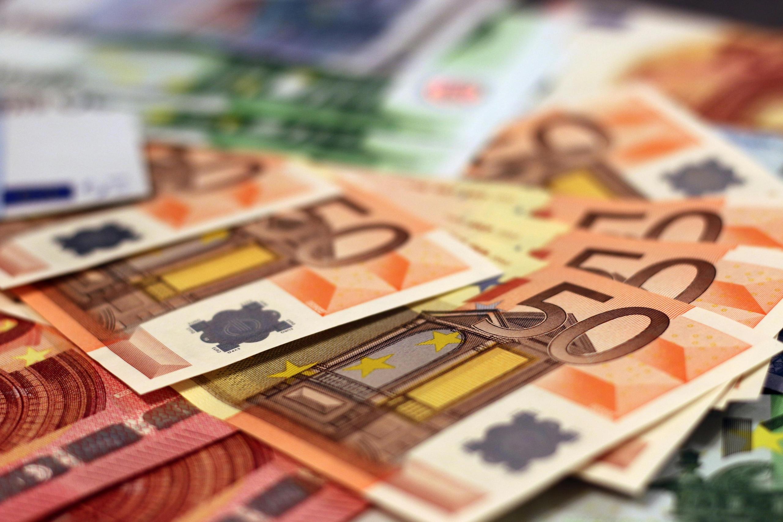 different denominations of Euro banknotes fanned out on flat surface