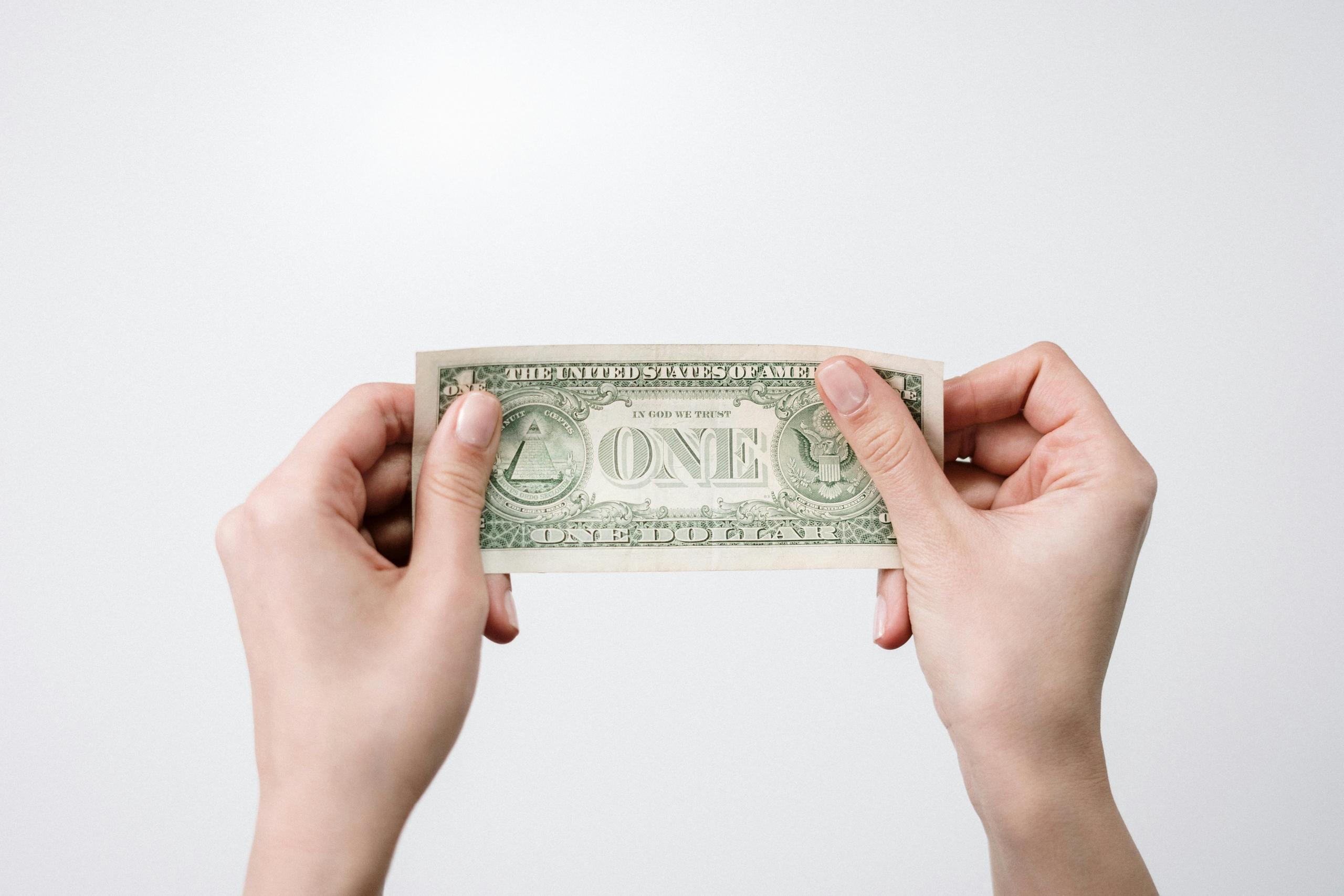 person holding green dollar currency in hands