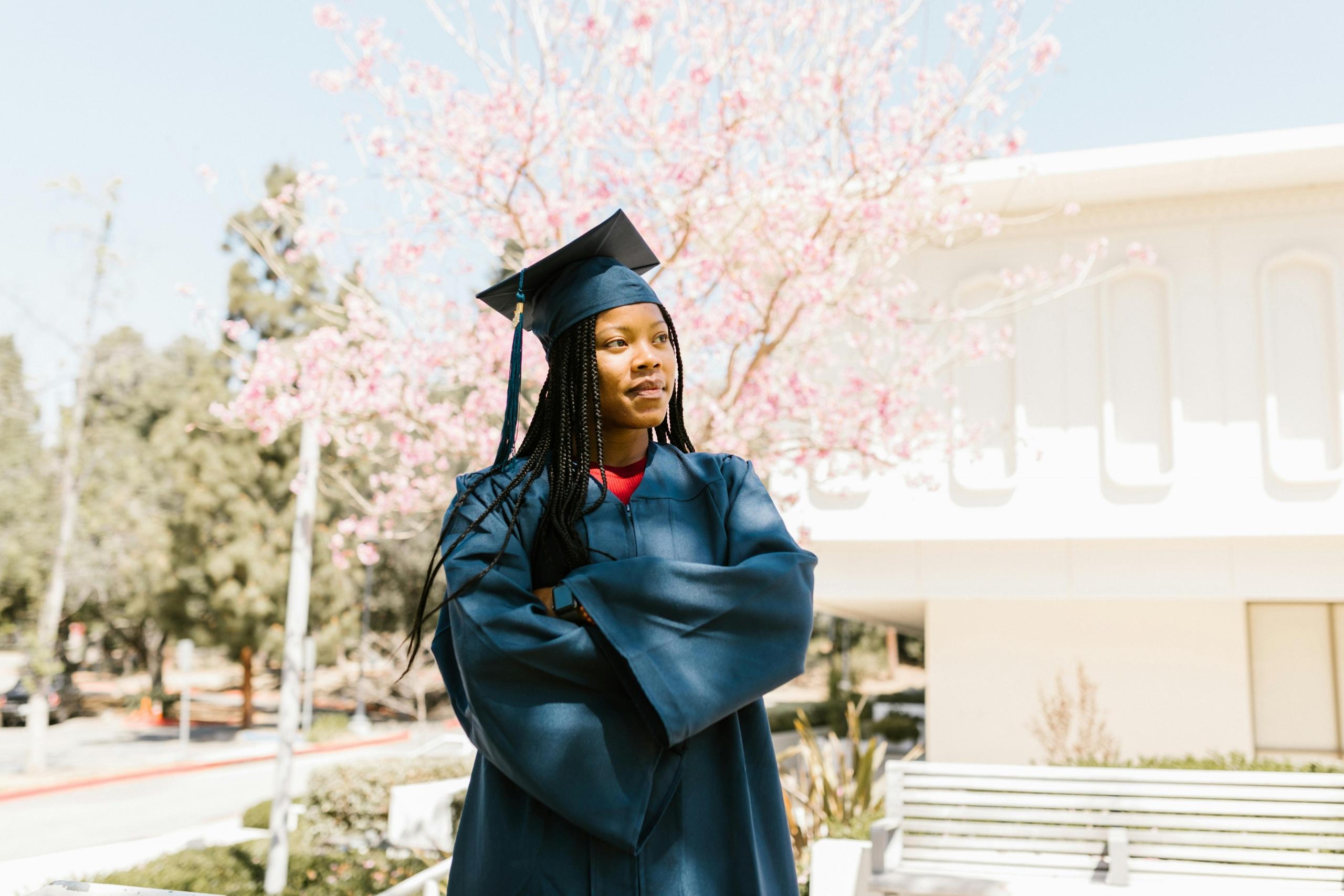 student graduating wearing black graduation gown and mortar board