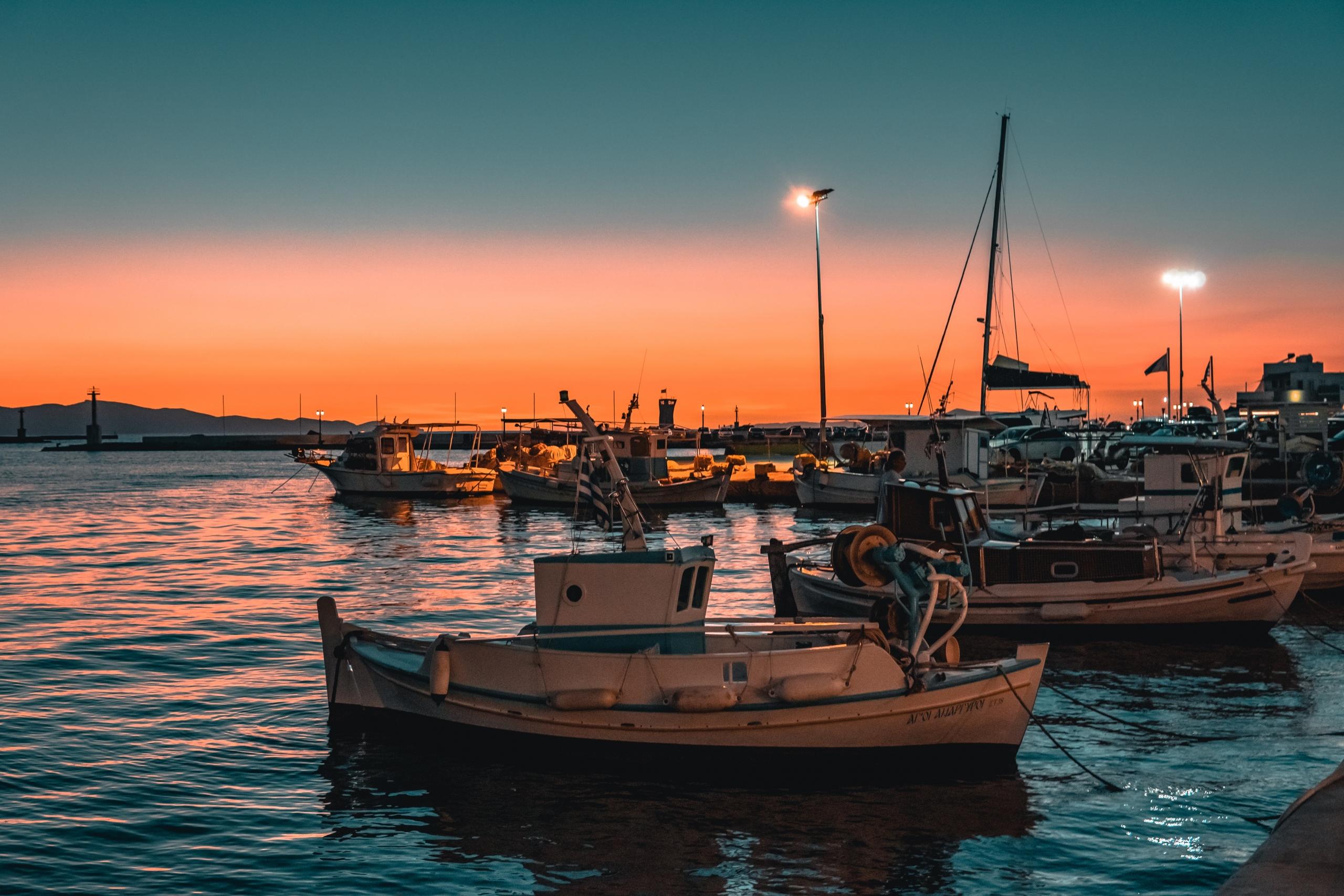 boats docked in harbour in greece at twilight