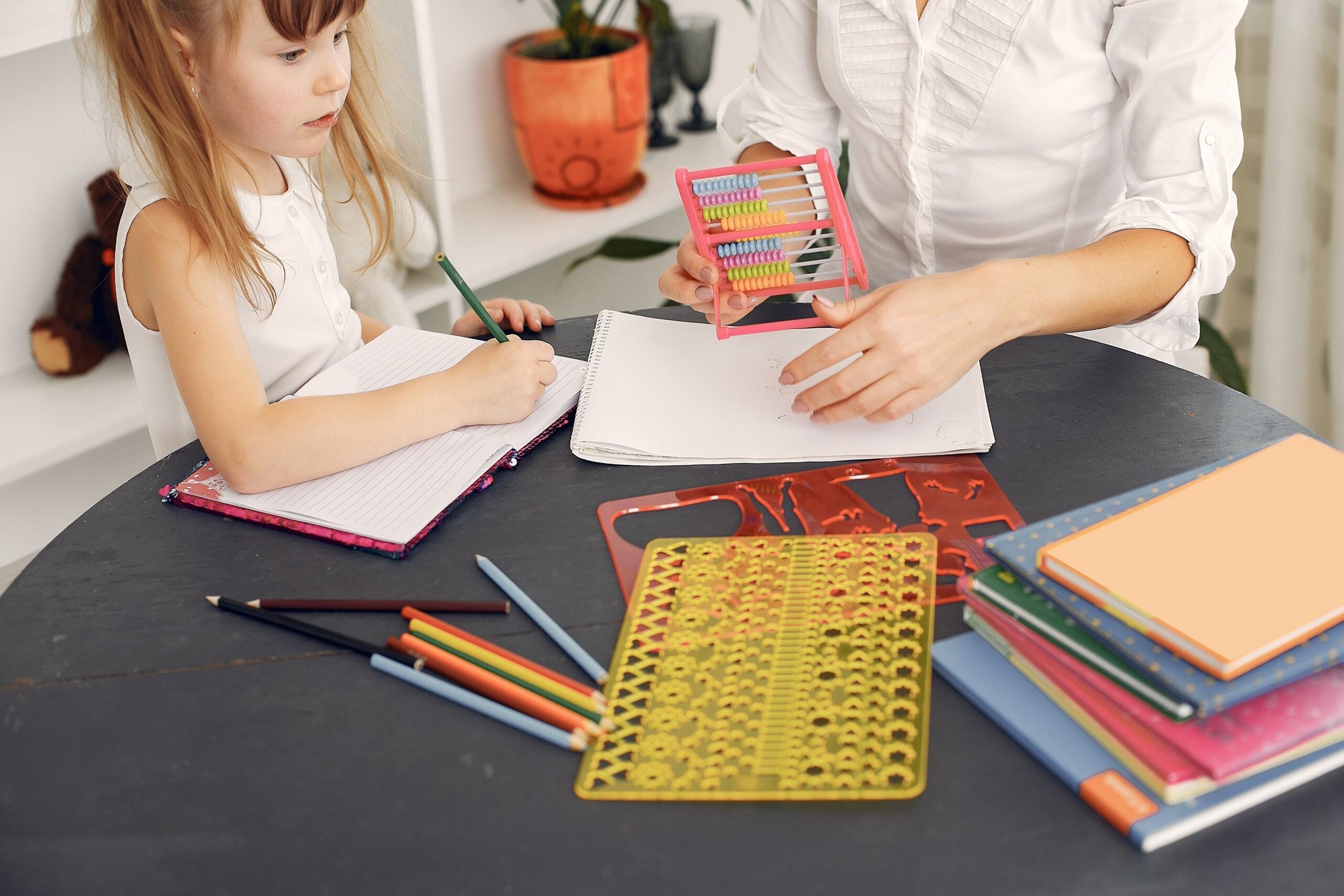 mom and daughter using abacus, and various stencils and stationery