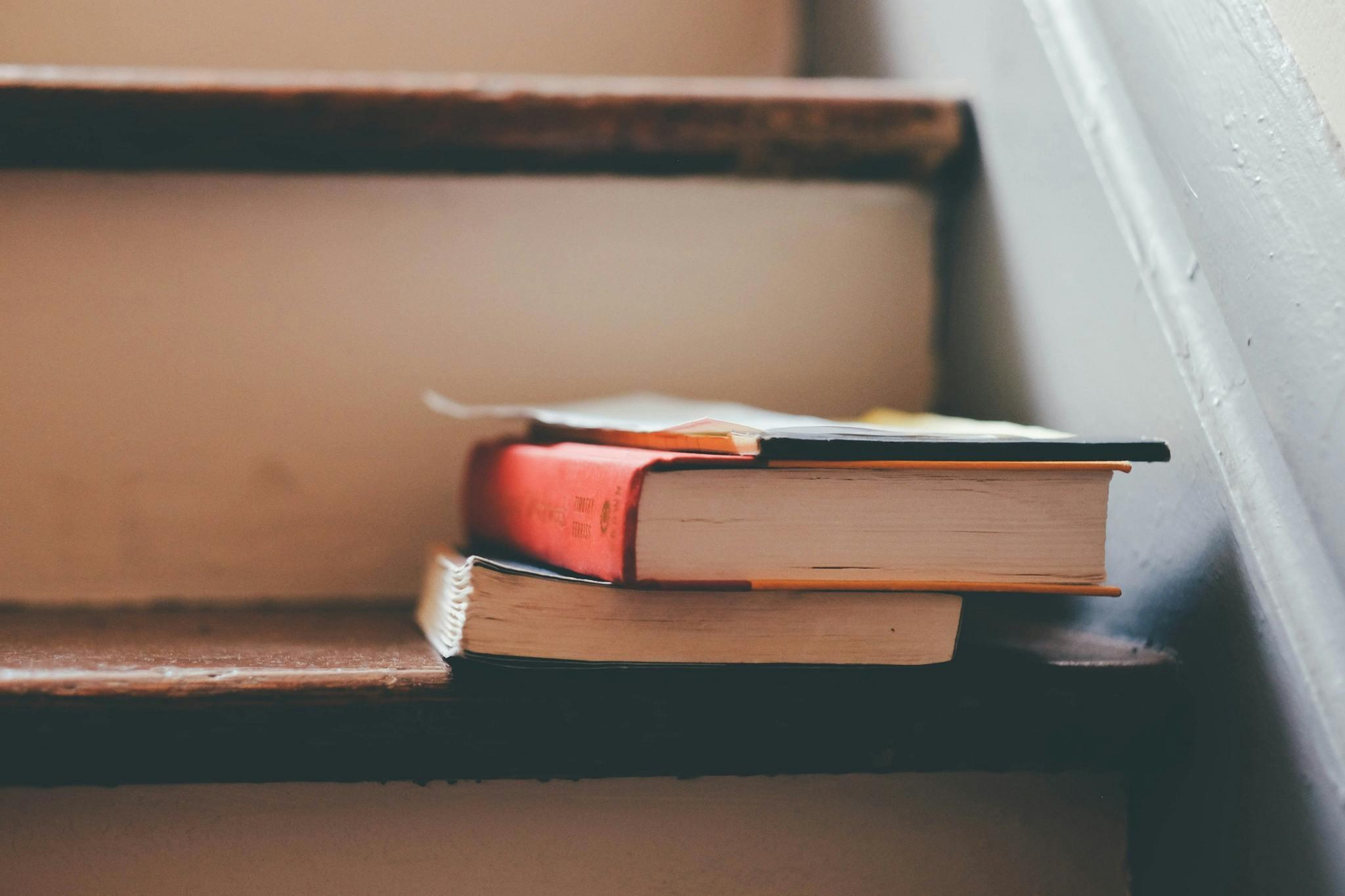 a pile of books on a staircase