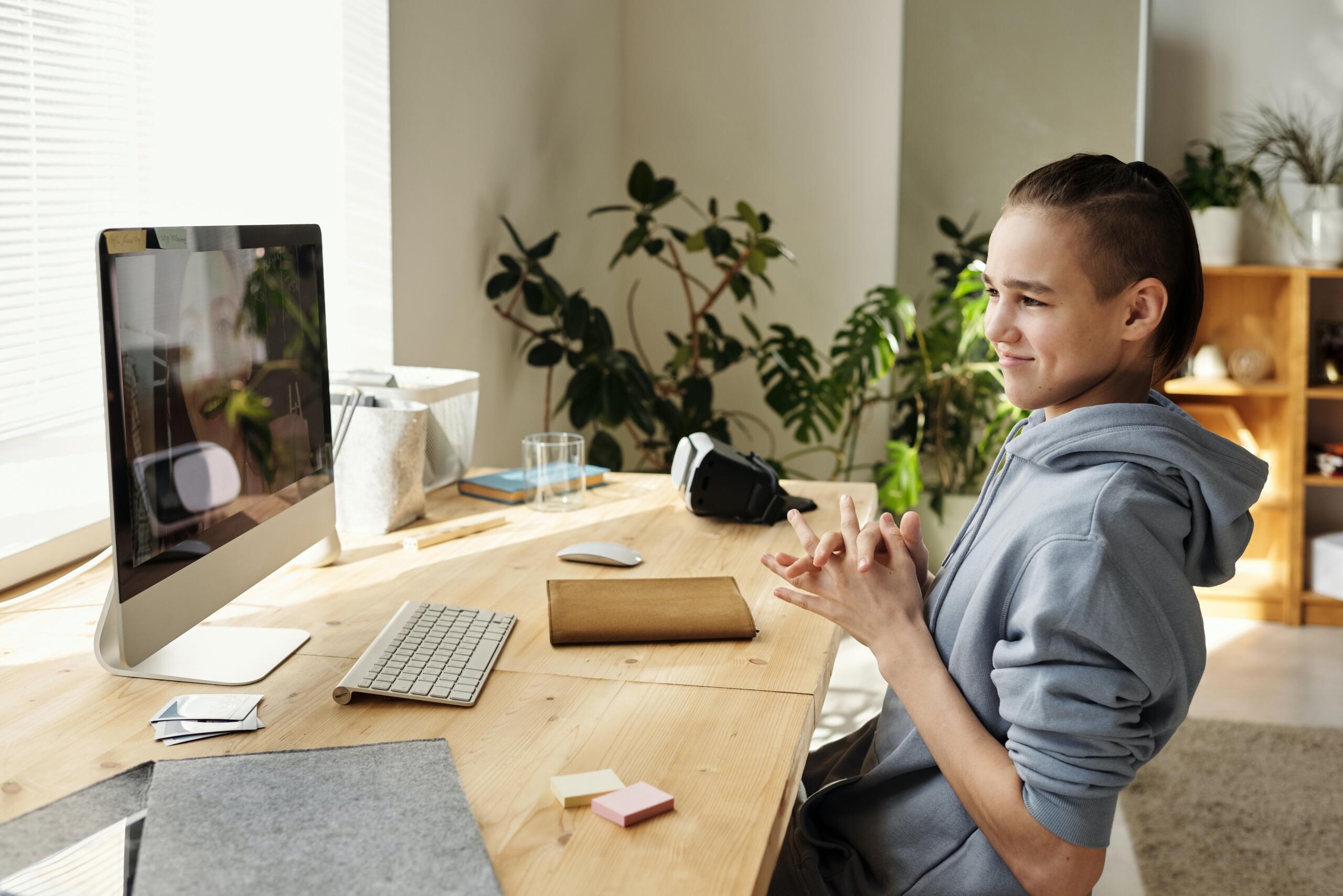 boy sitting at desk in front of computer screen