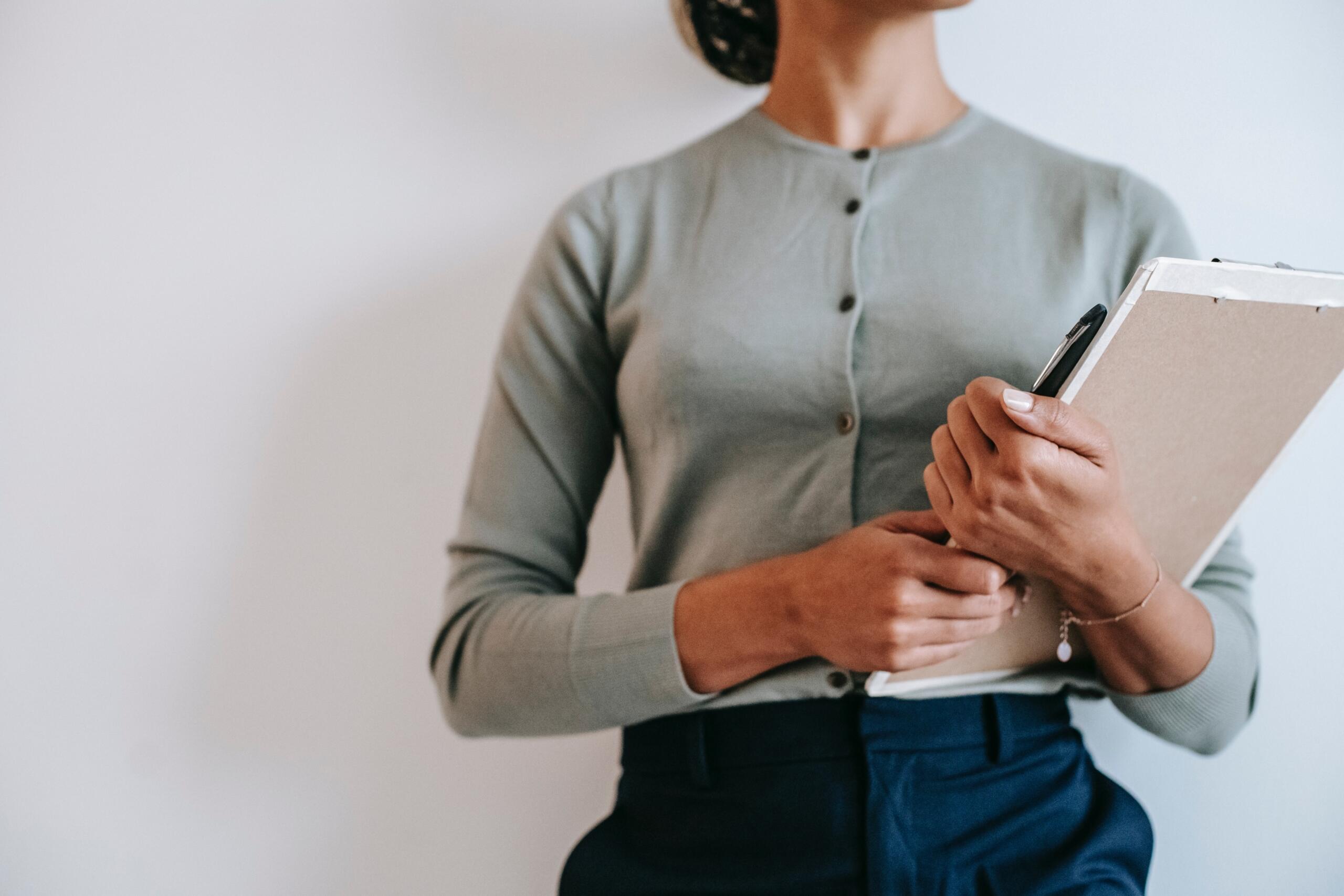 woman holding a clipboard and pen in her hand