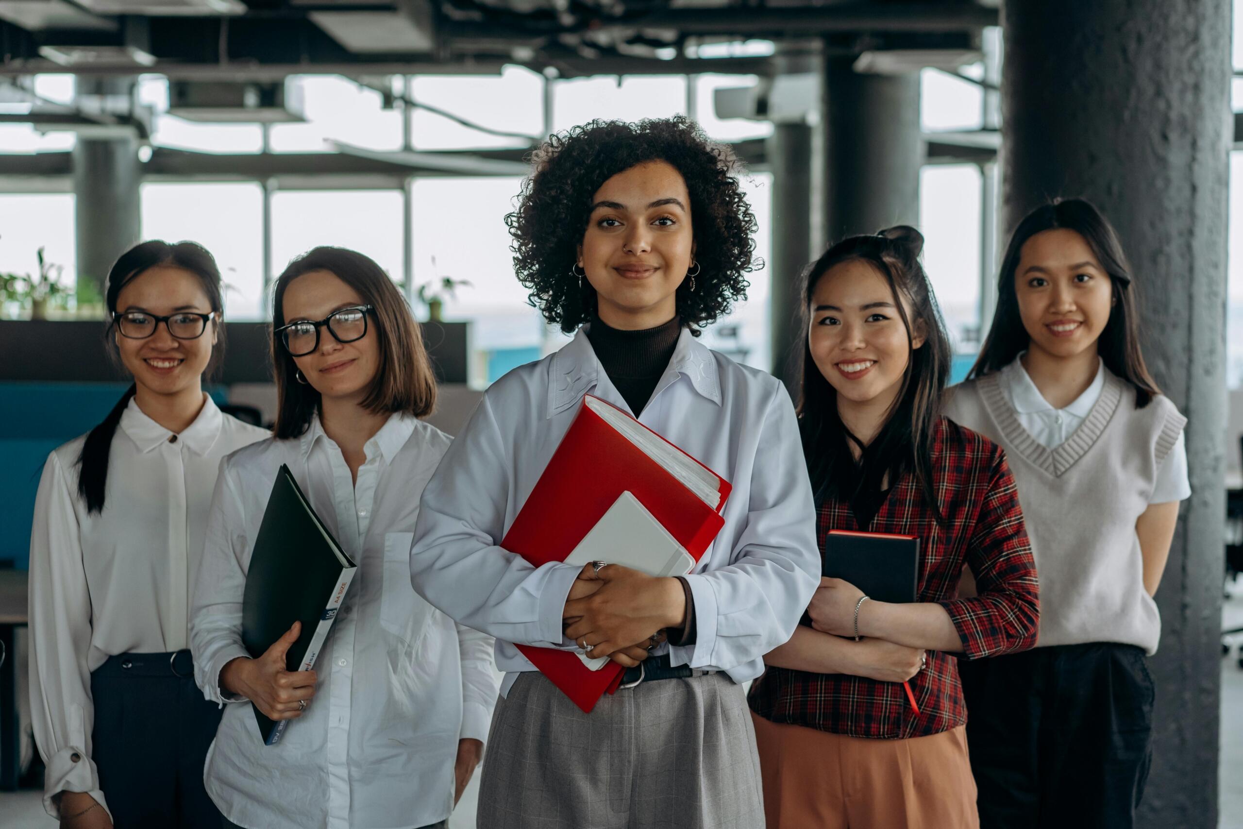 women holding files and walking through office