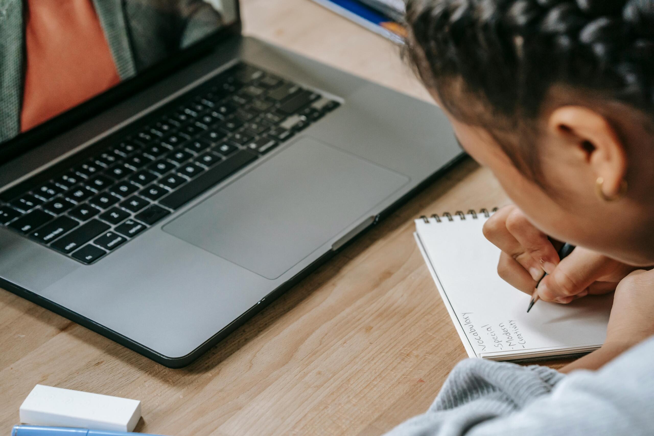 young girl using laptop to take an online lesson