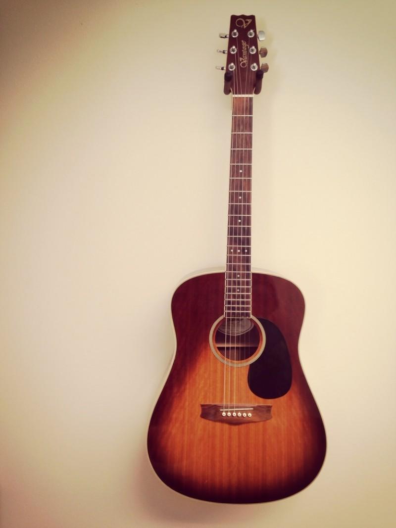 An acoustic guitar attached to a wall