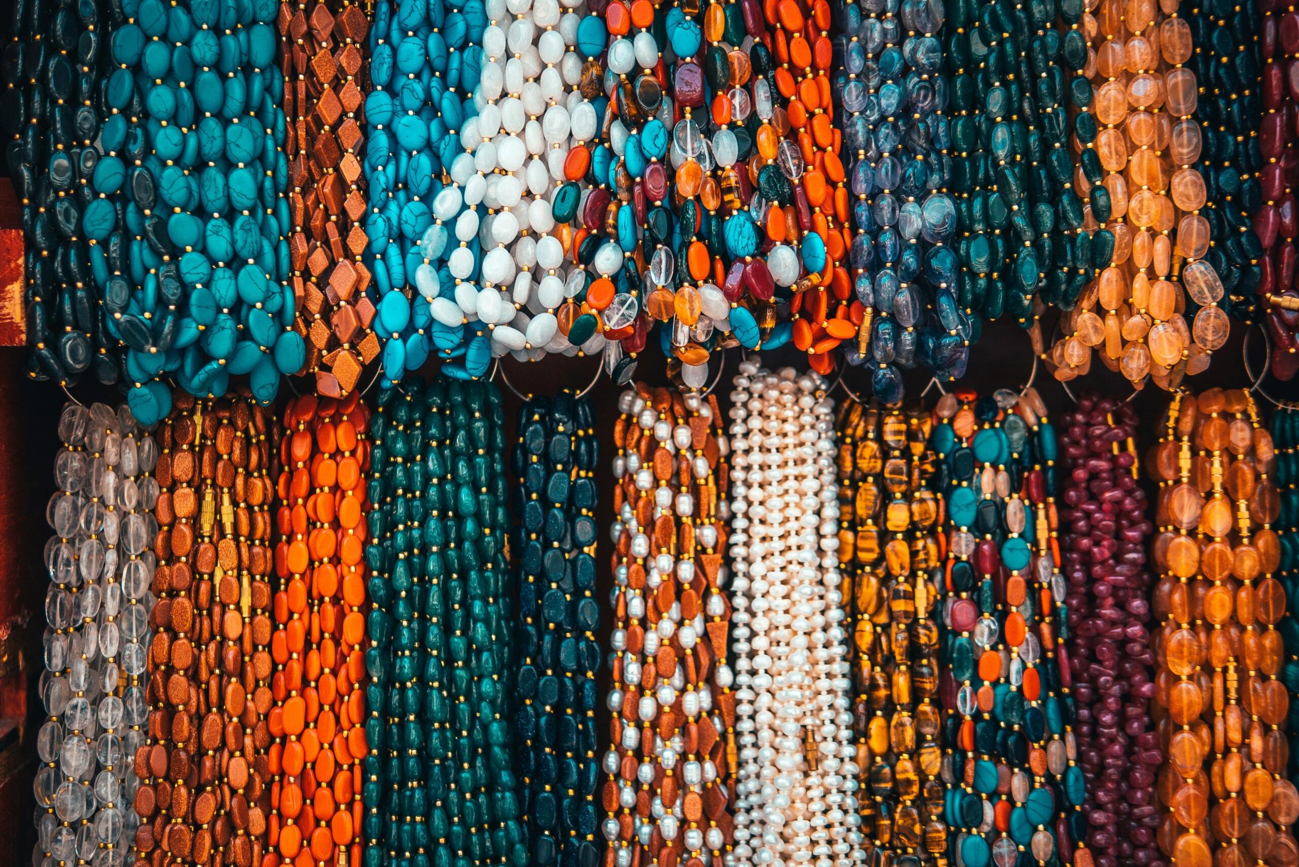 assorted colourful beaded necklaces hanging in a display