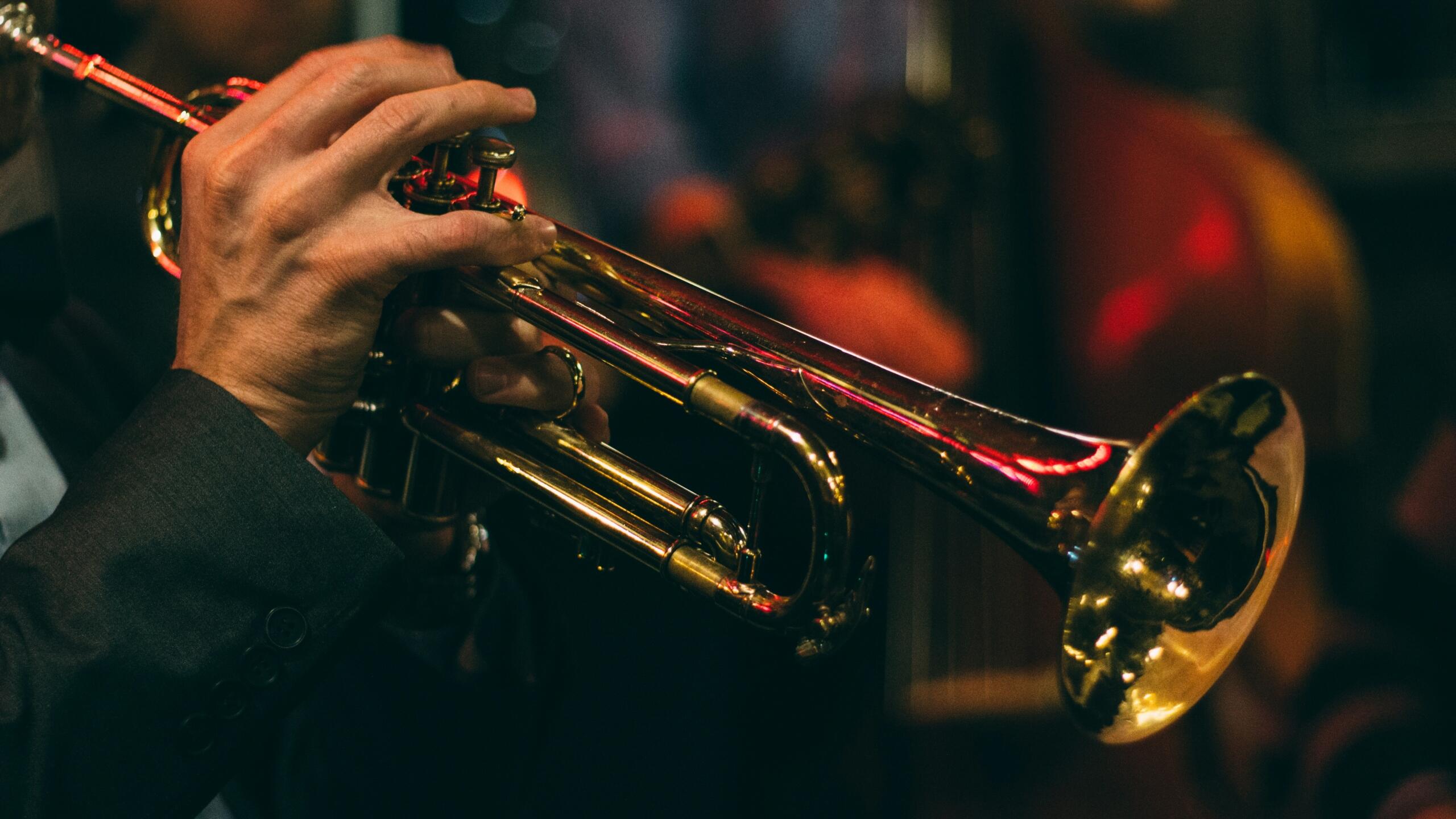 close-up of the hand of a trumpet player playing trumpet in a dark space