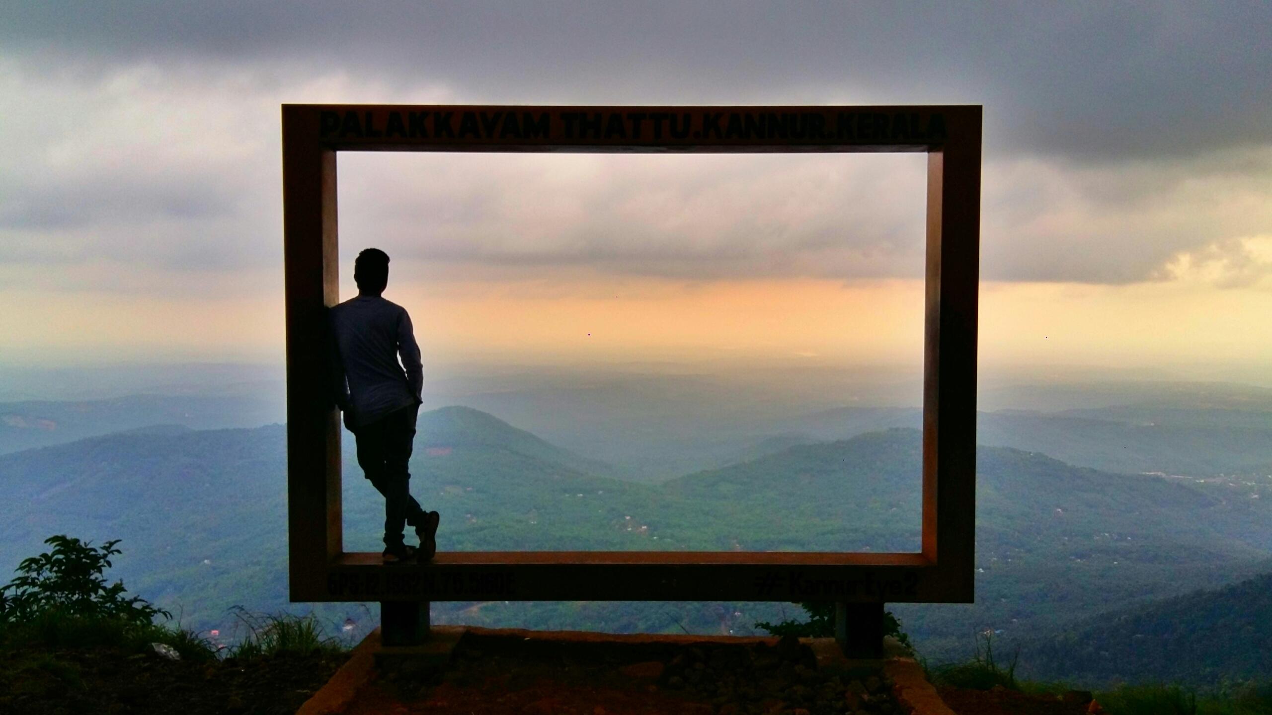 A silhouette of a man looking through a framed natural landscape.
