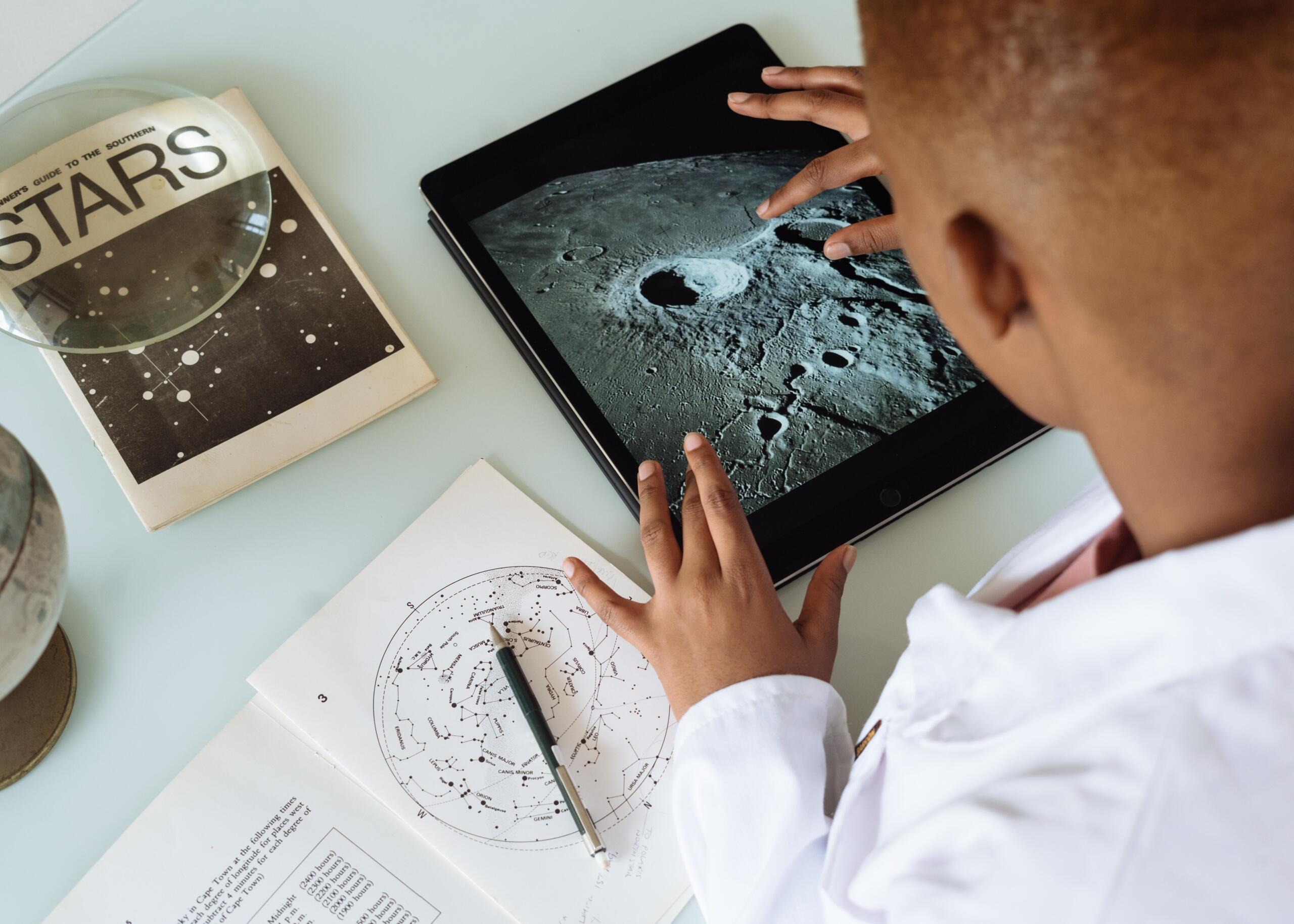 a boy using a tablet to look at images of the moon
