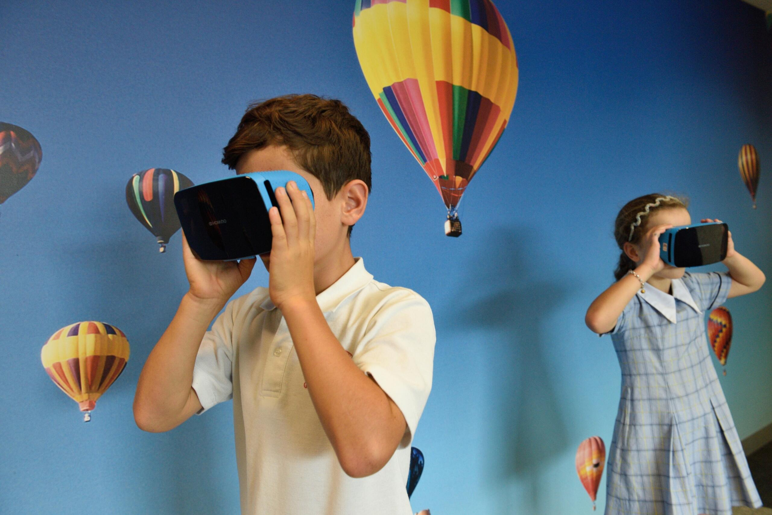 a girl and a boy in school uniforms using augmented reality smart goggles