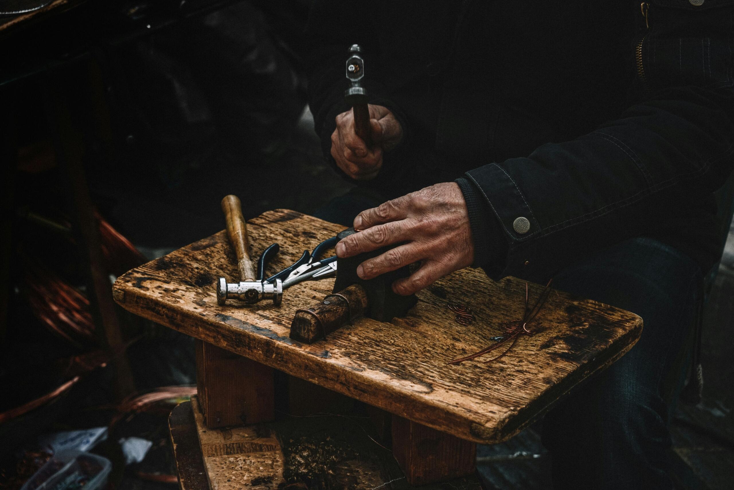 A craftsman's hands on a workbench.