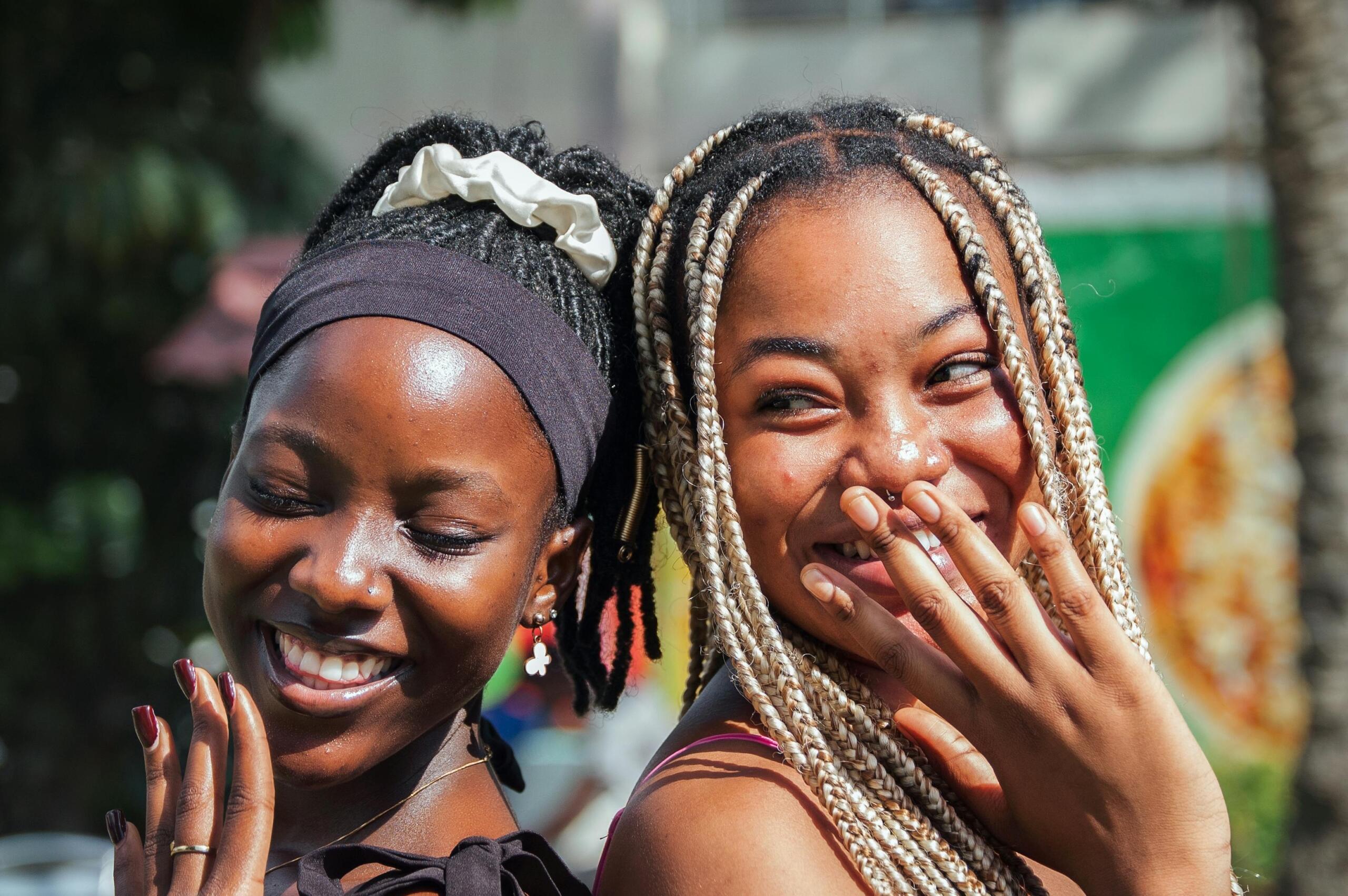 two happy young women standing back-to-back