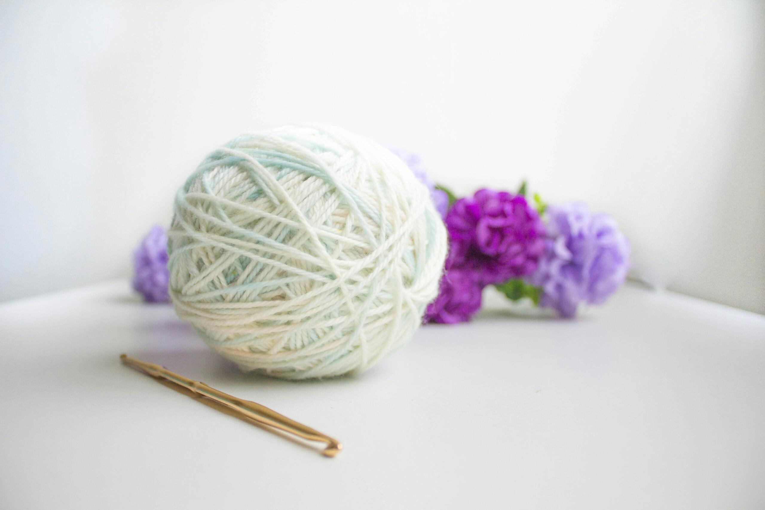 A simple image of a ball of wool and a sprig of lavender.