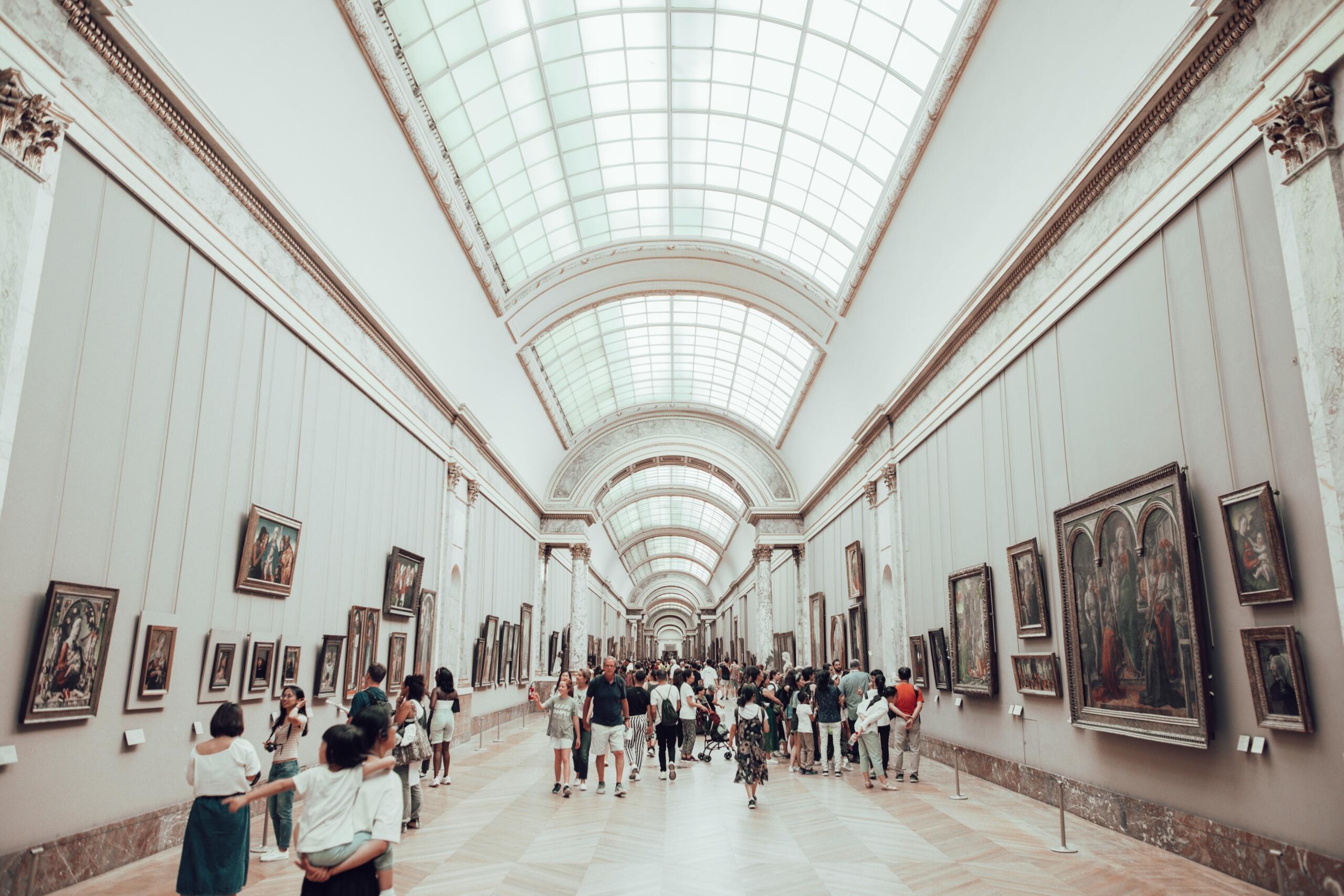 People walking in a white museum building