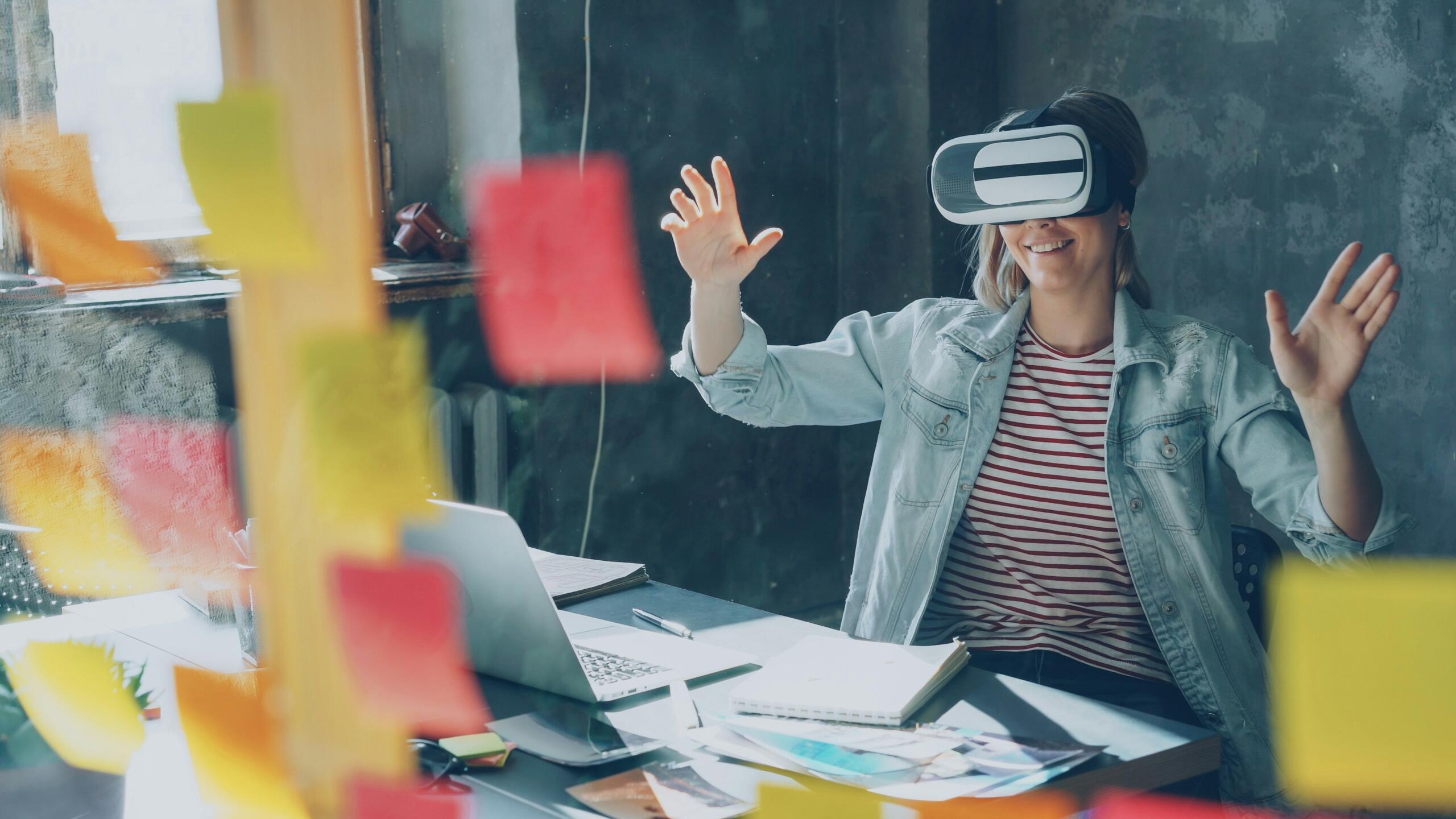 woman sitting behind a desk in an office wearing a pair of augmented reality smart glasses