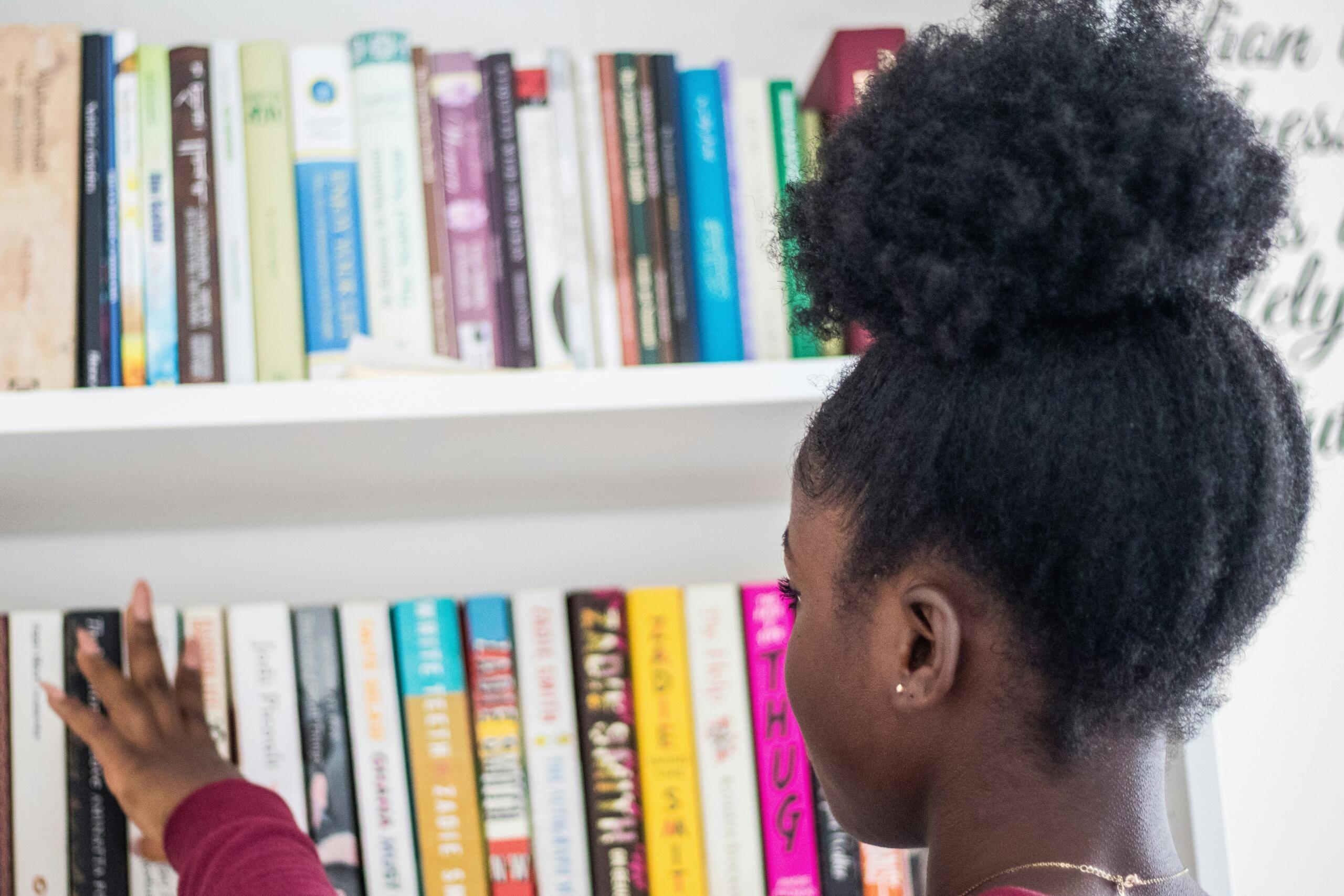 A young learner eyes a library of books.