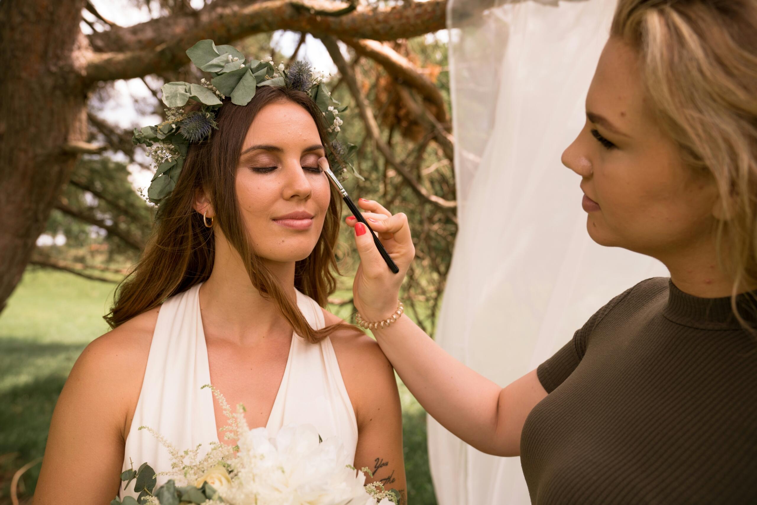 A make-up artist finishes off her work on a bride.