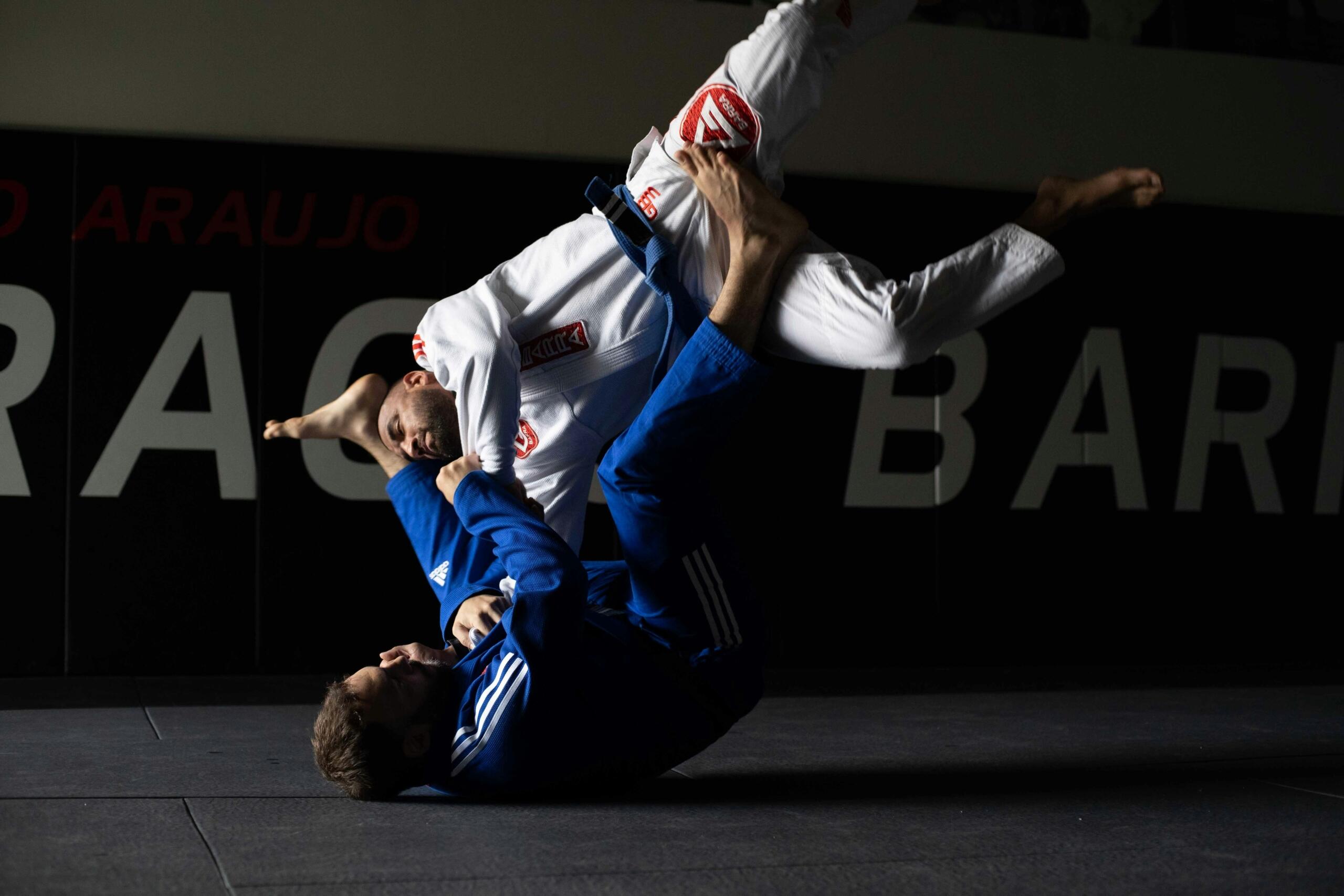 Judo opponents grapple on a mat.