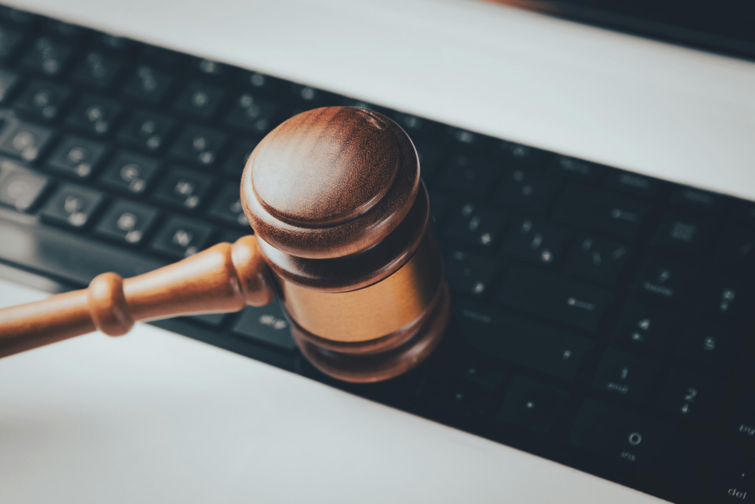 a gavel held up in front of a computer keyboard