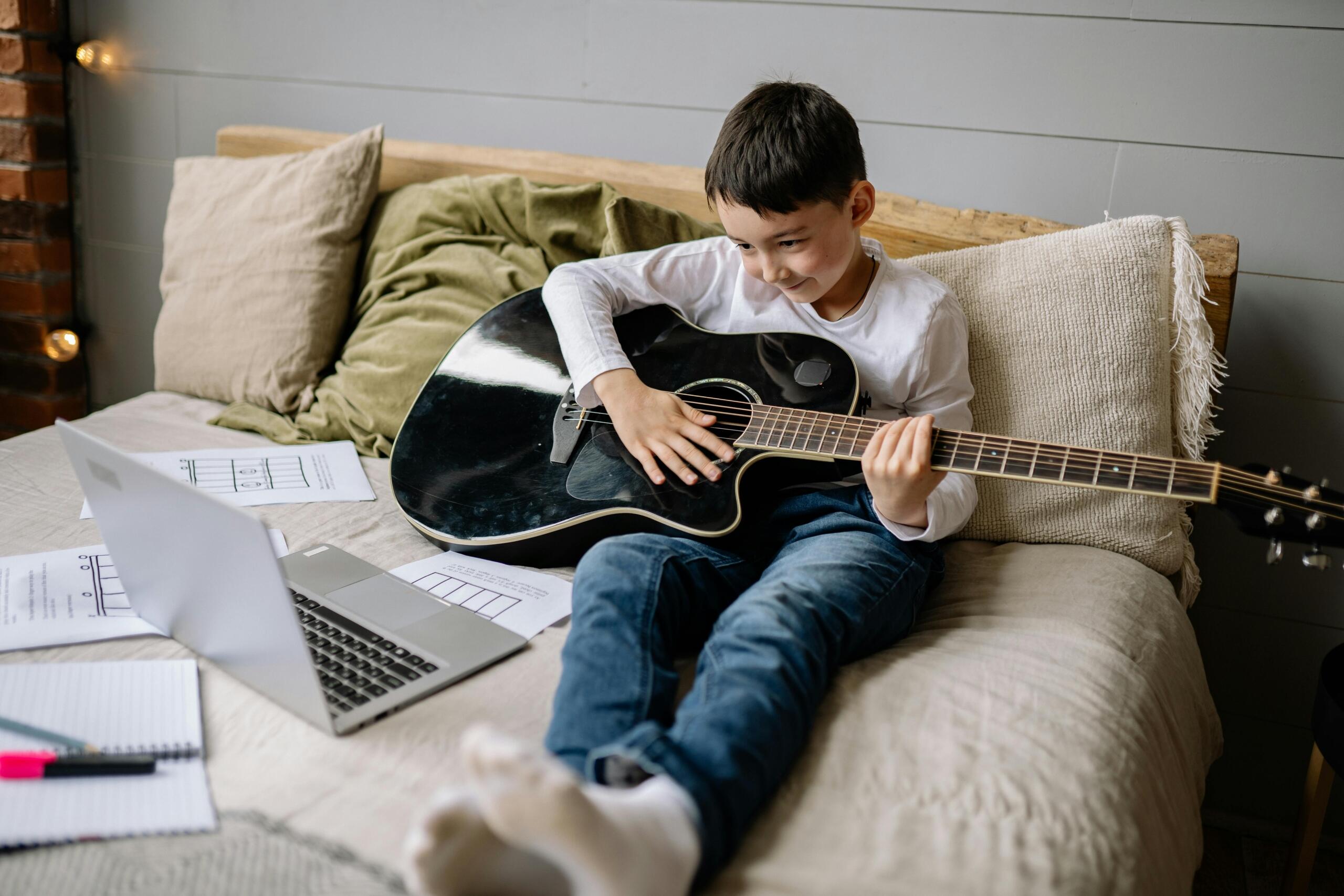 A child learns guitar online.