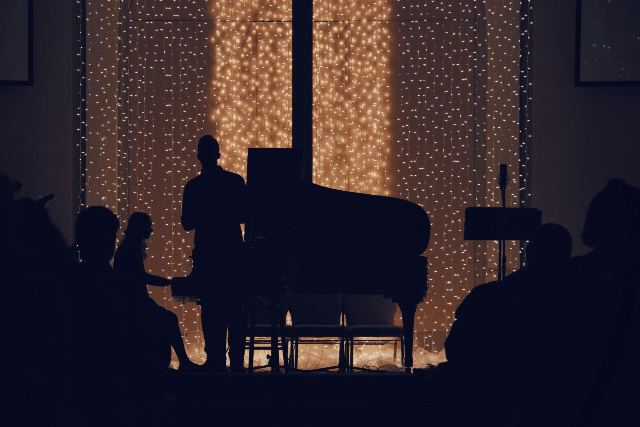 A classical piano concert silhouetted by stage lighting.