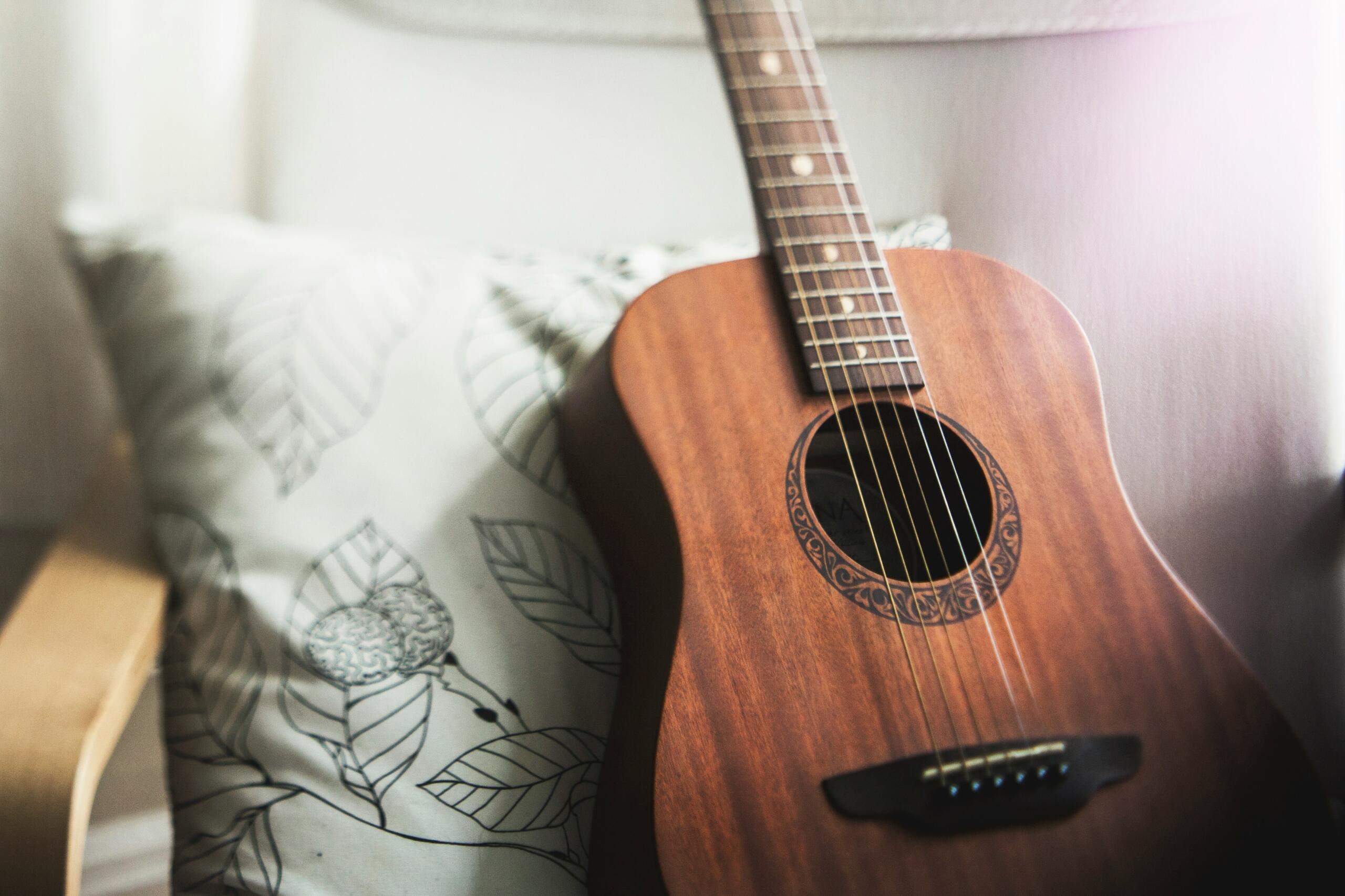 Guitar against a floral pillow