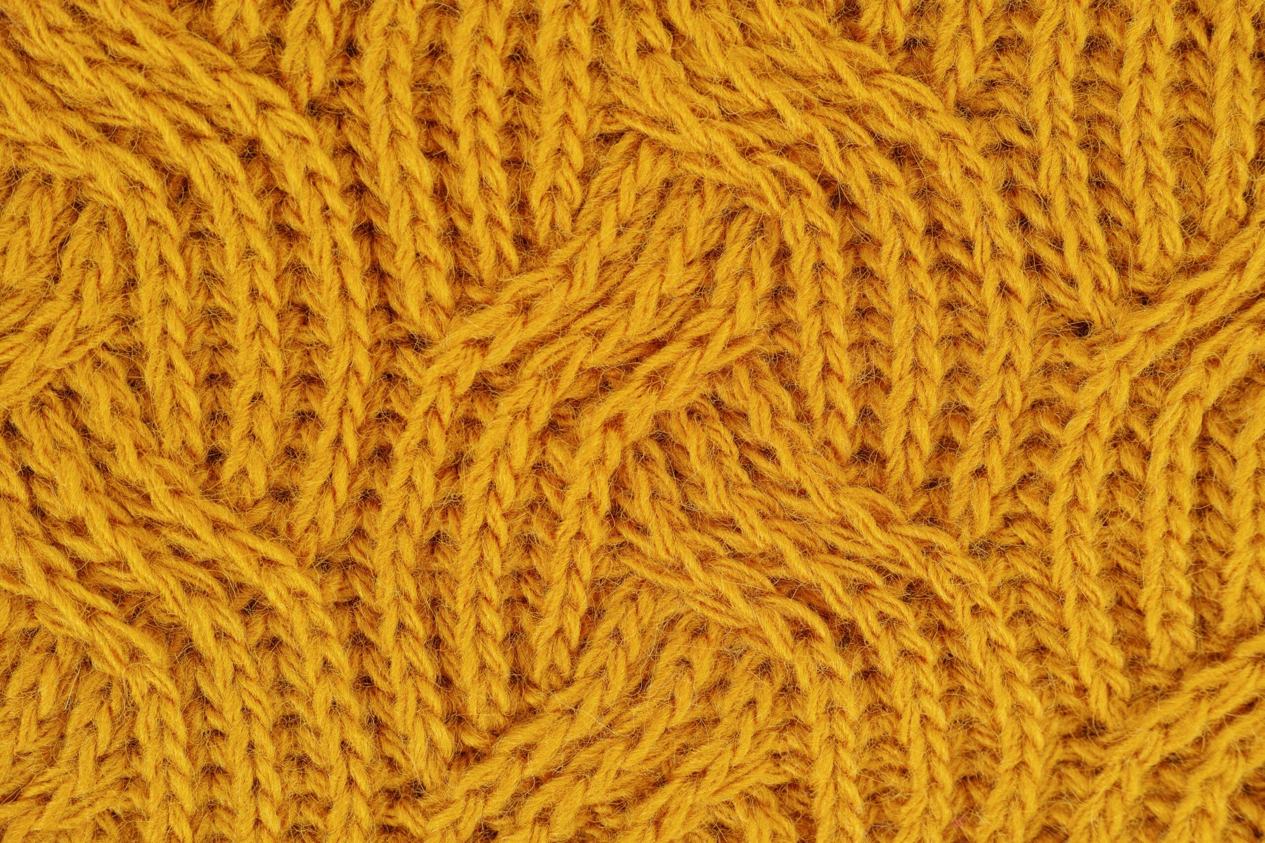 close up of mustard yellow knitted garment with intricate pattern
