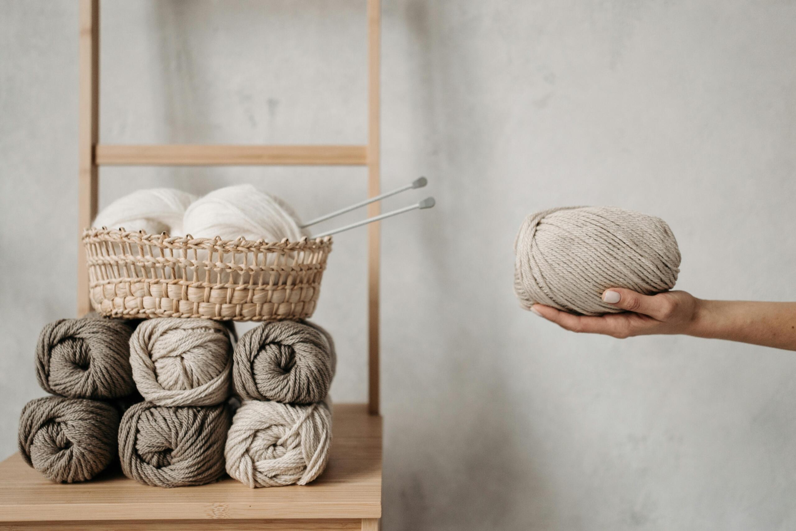 skeins of wool arranged on a wooden shelf