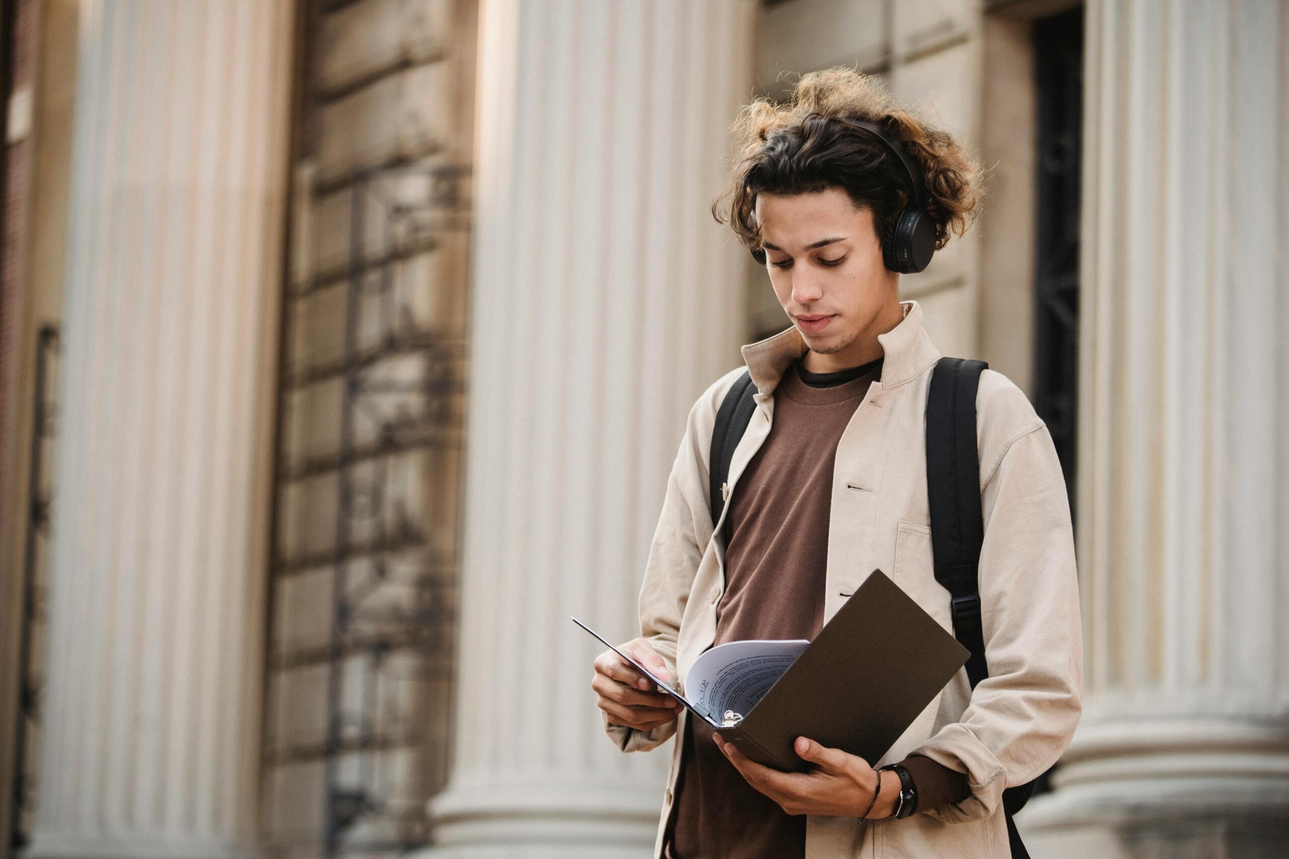student wearing headphones looking at notes in a file